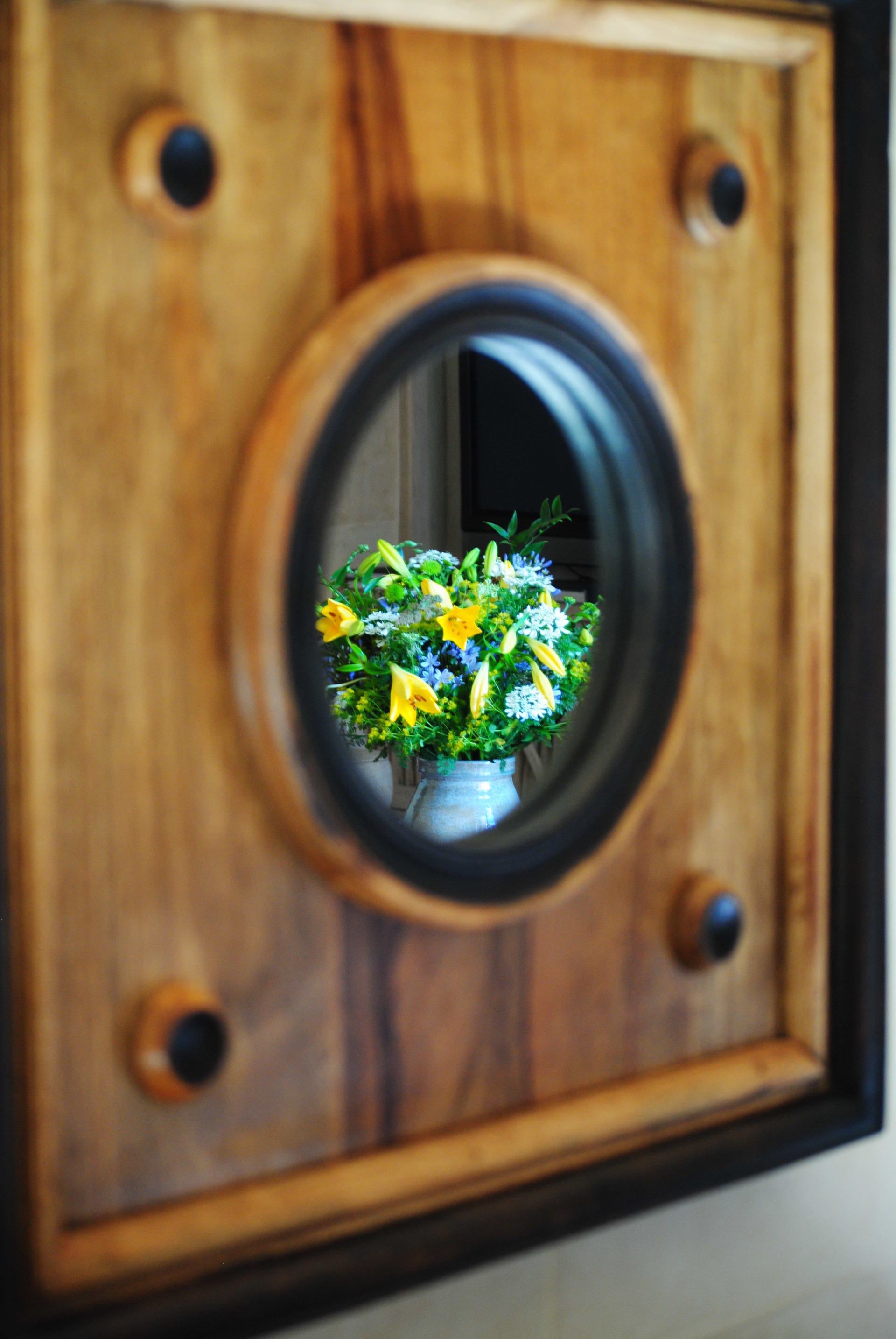A picture of flowers in a vase in a wooden frame