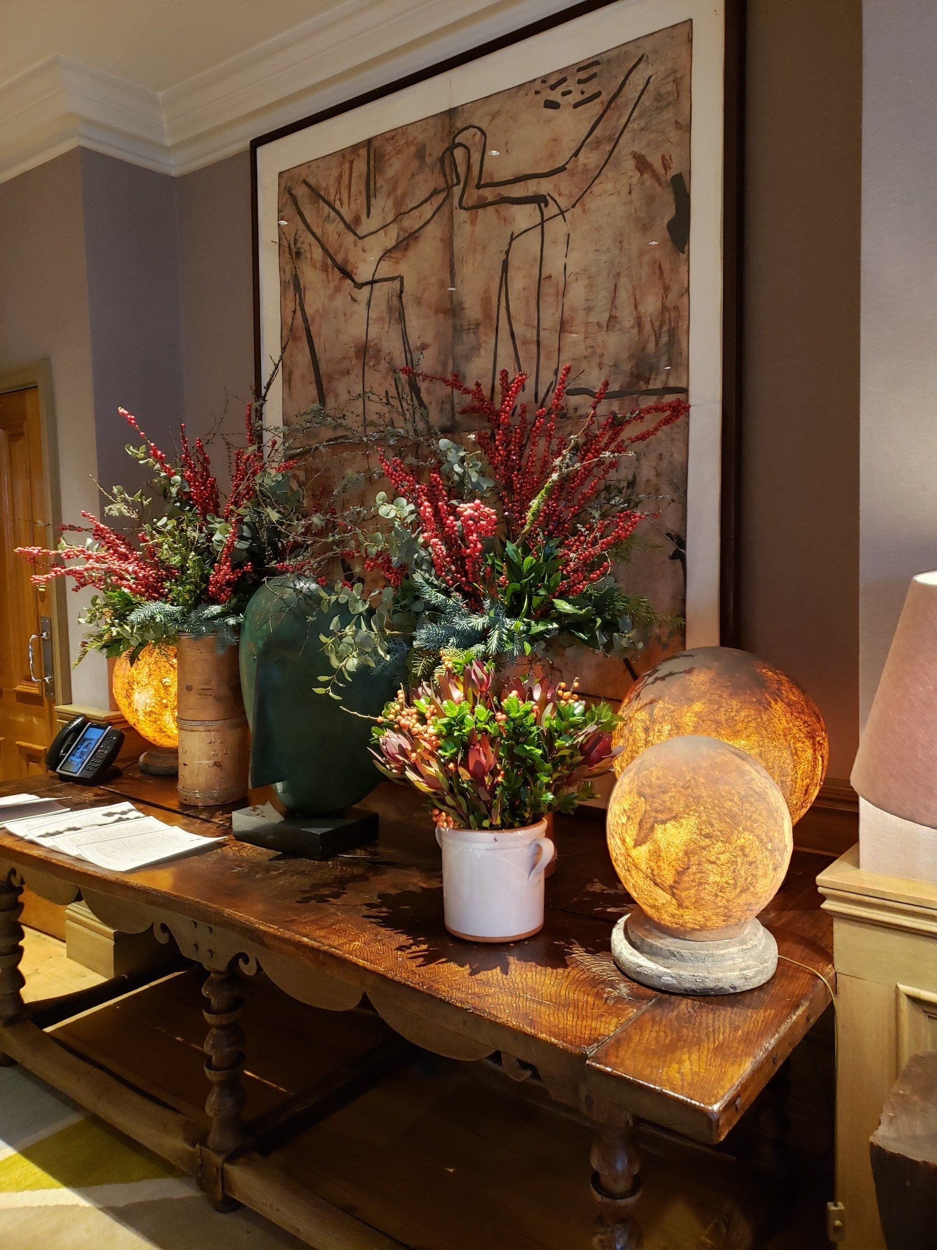 A table with vases of flowers and lamps on it
