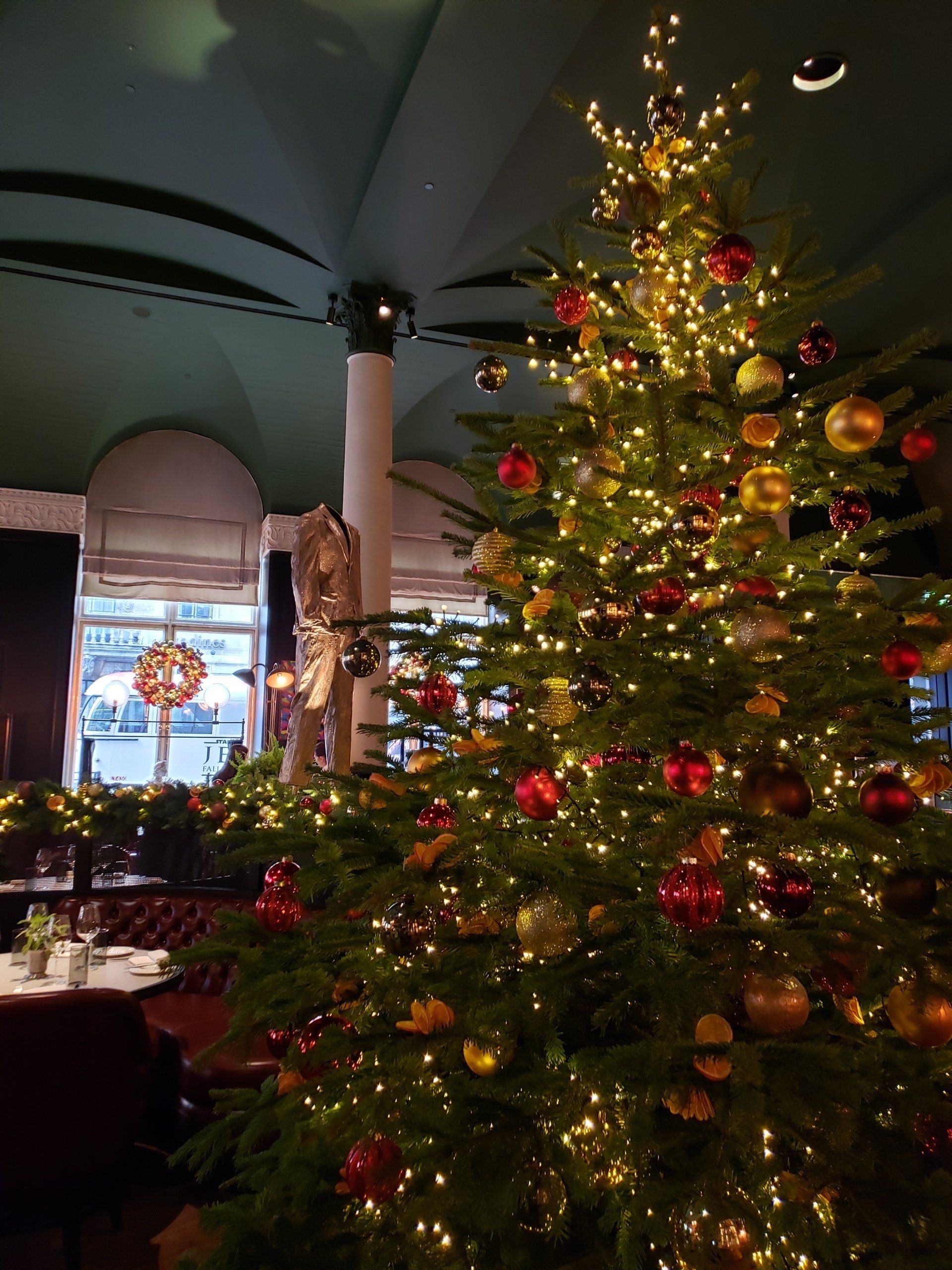 A large christmas tree is sitting in a restaurant.