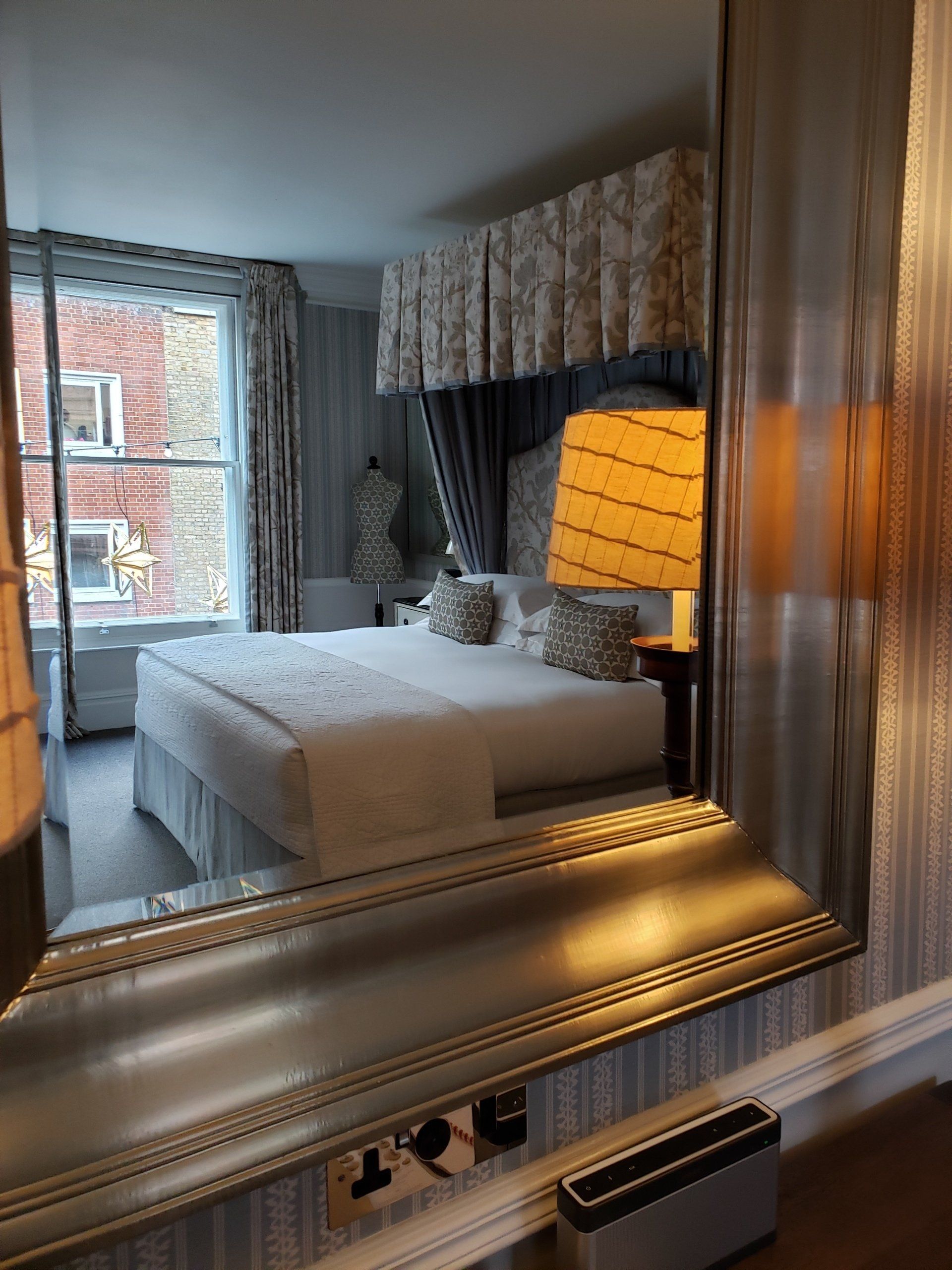 A hotel room with a large bed and a large mirror