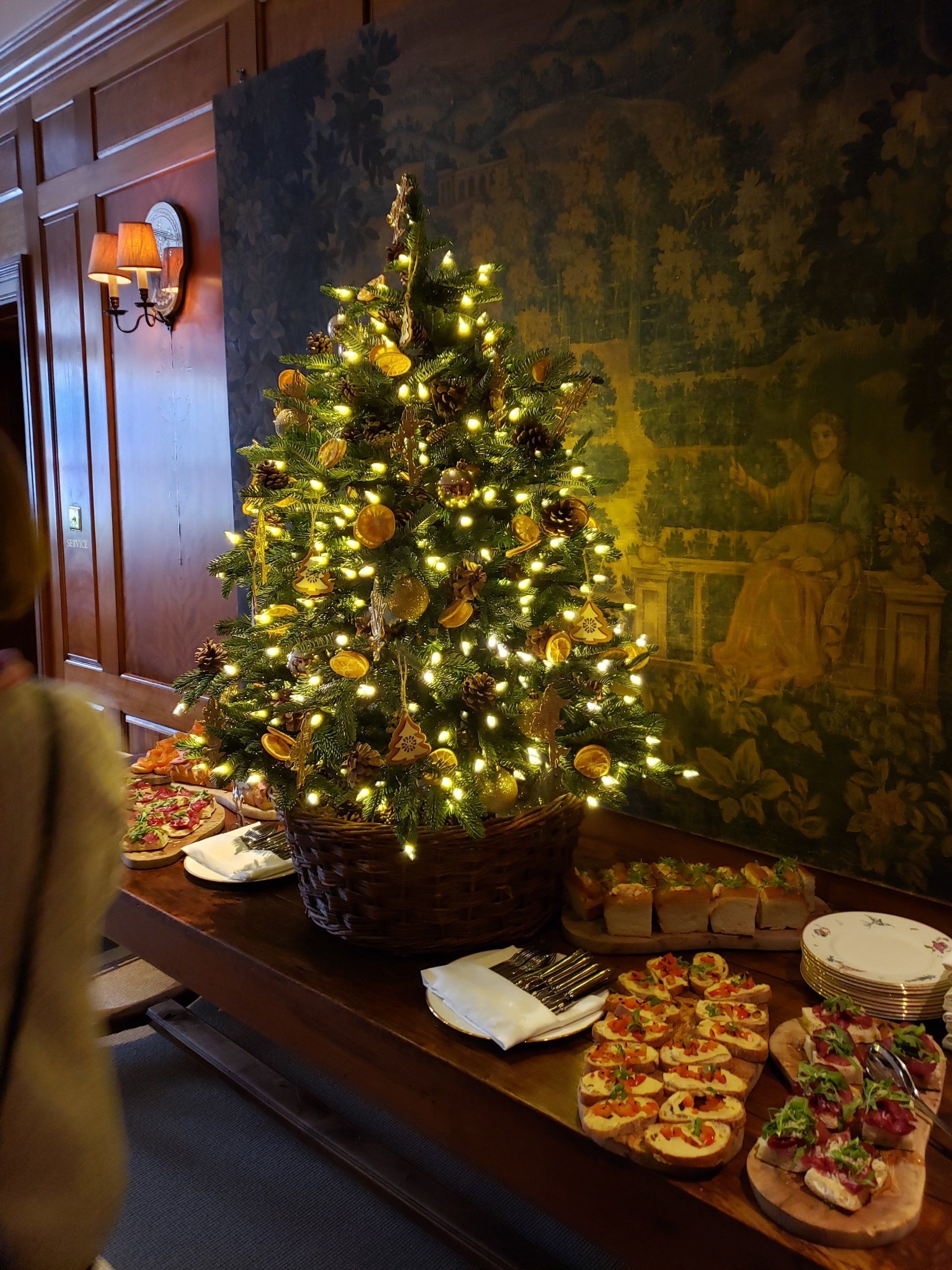 A christmas tree is sitting on top of a table with food on it.