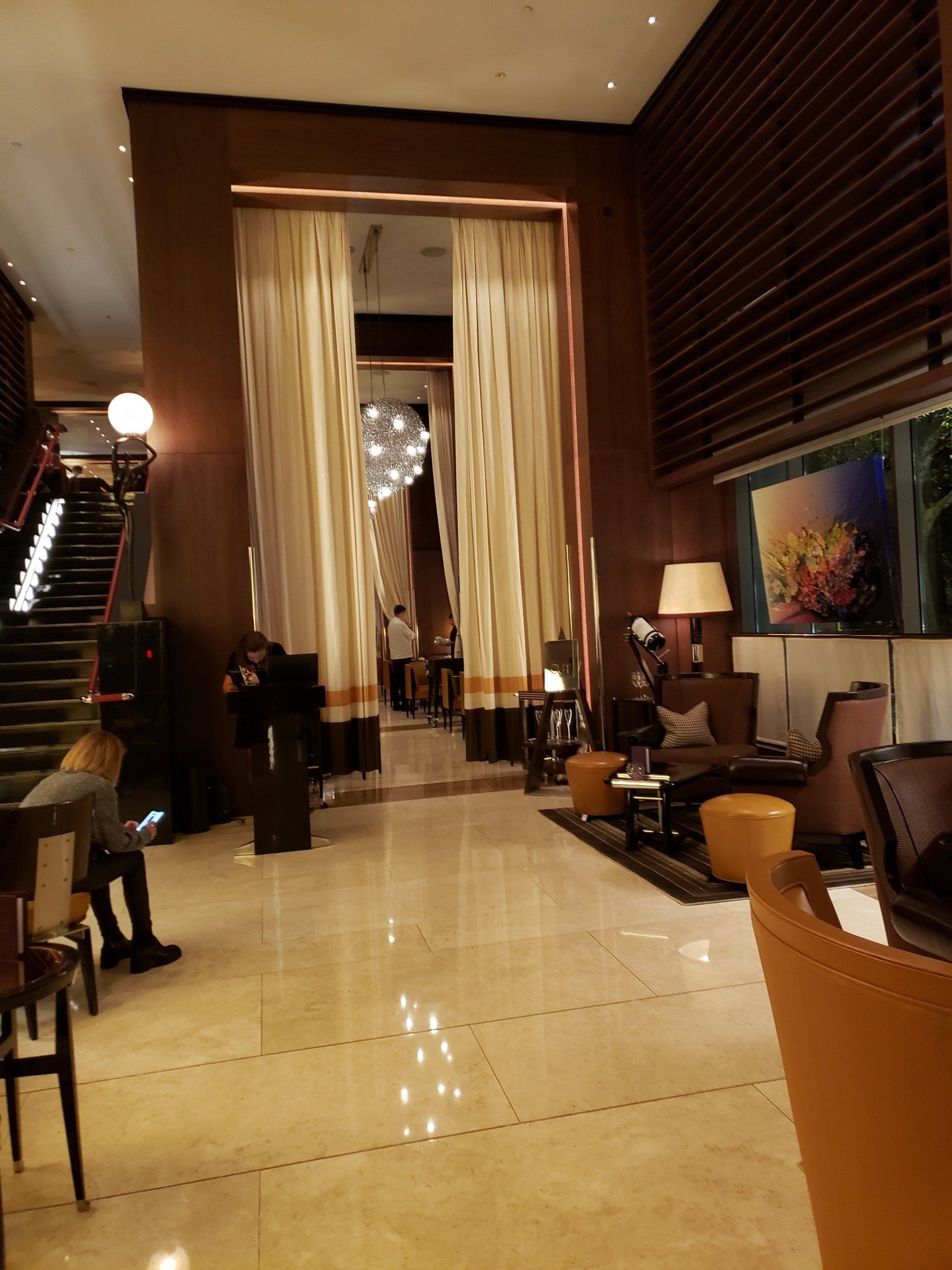 A hotel lobby with a staircase leading up to the second floor