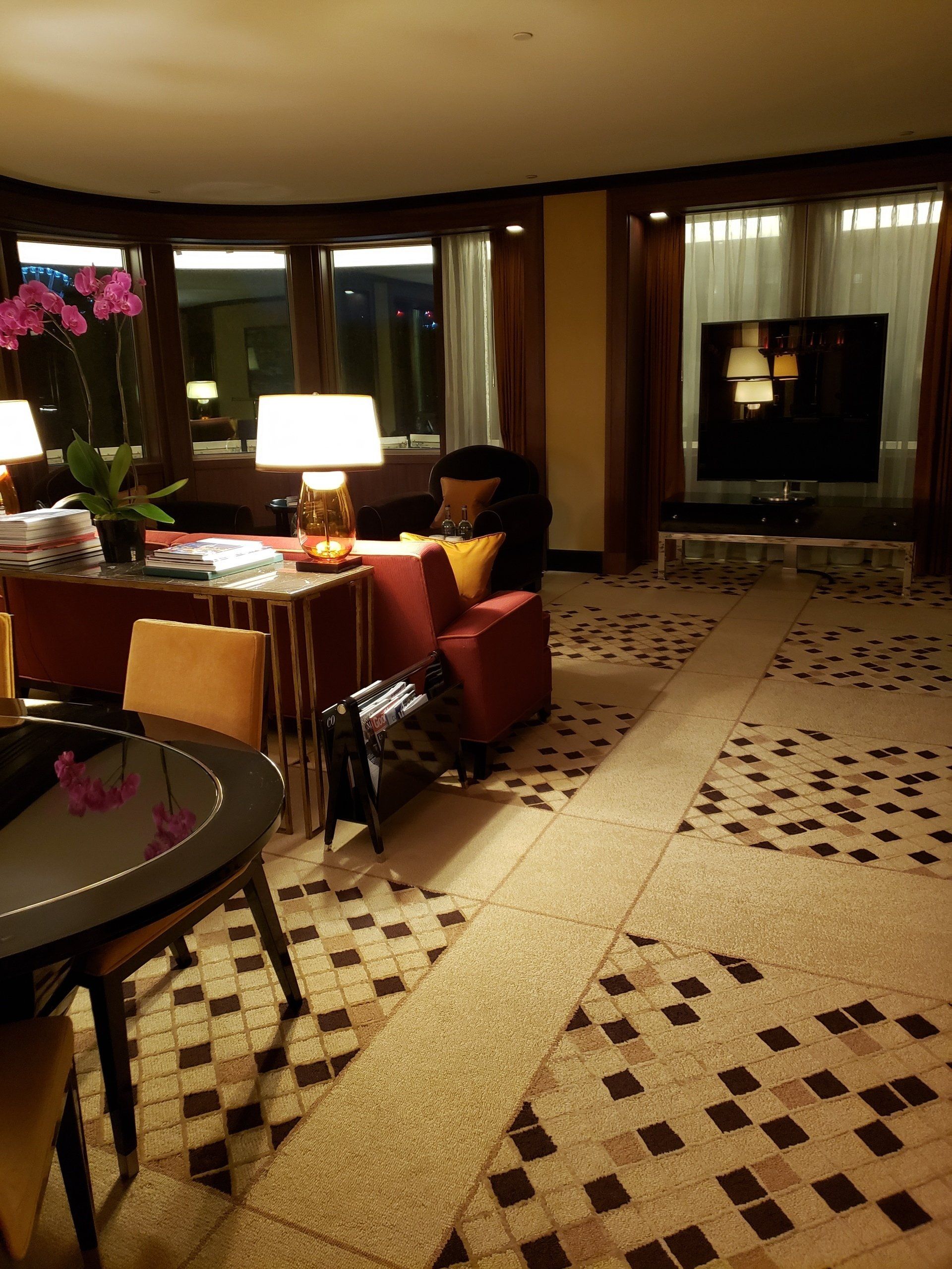 A living room with a table chairs and lamps