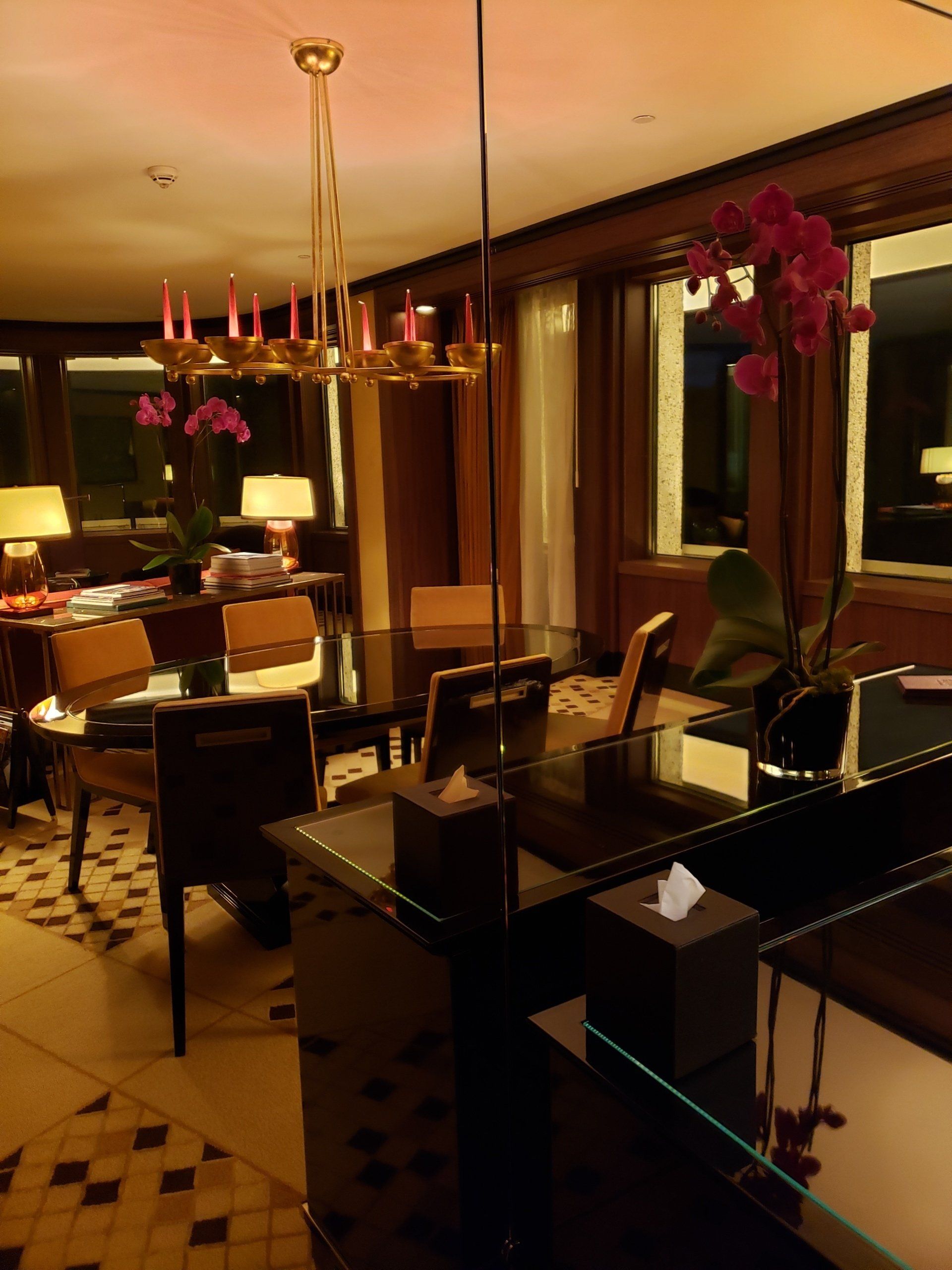 A room with a table and chairs and a mirror