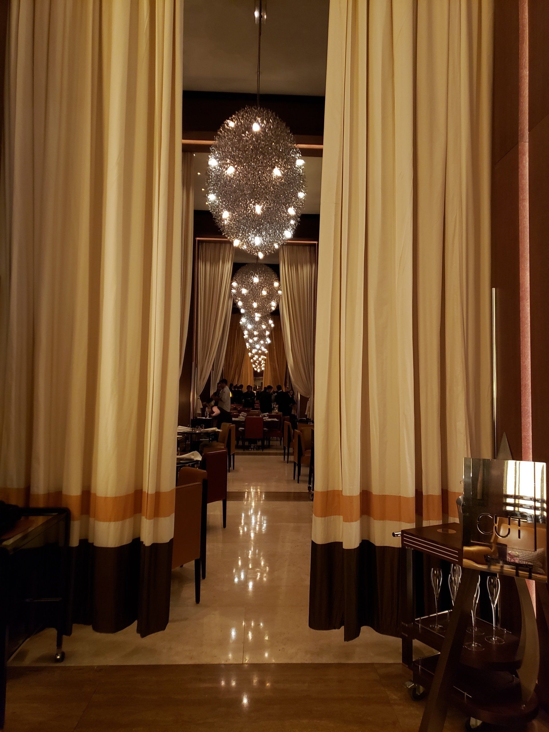 A room with a lot of curtains and a chandelier