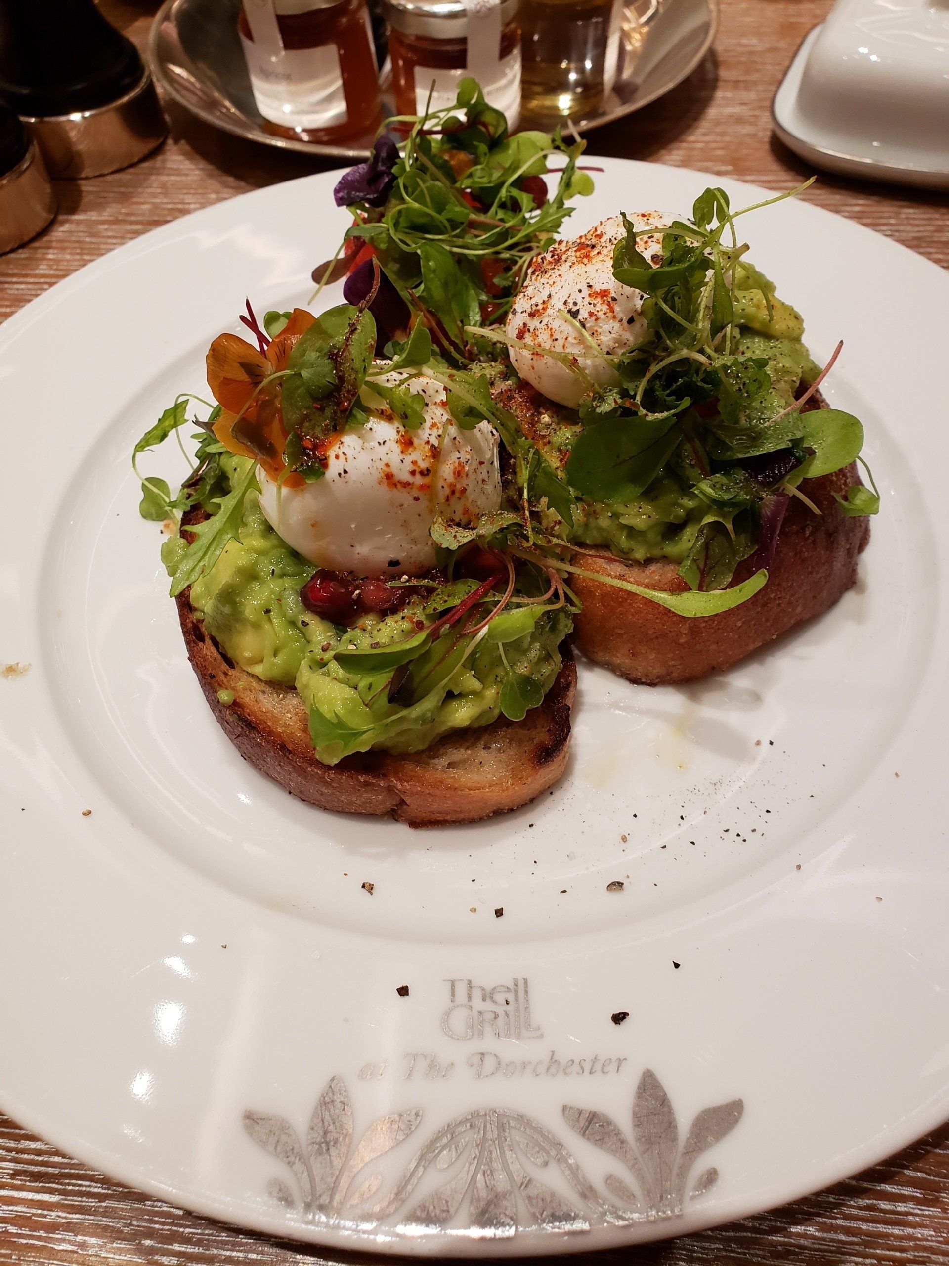 A white plate topped with avocado toast and poached eggs