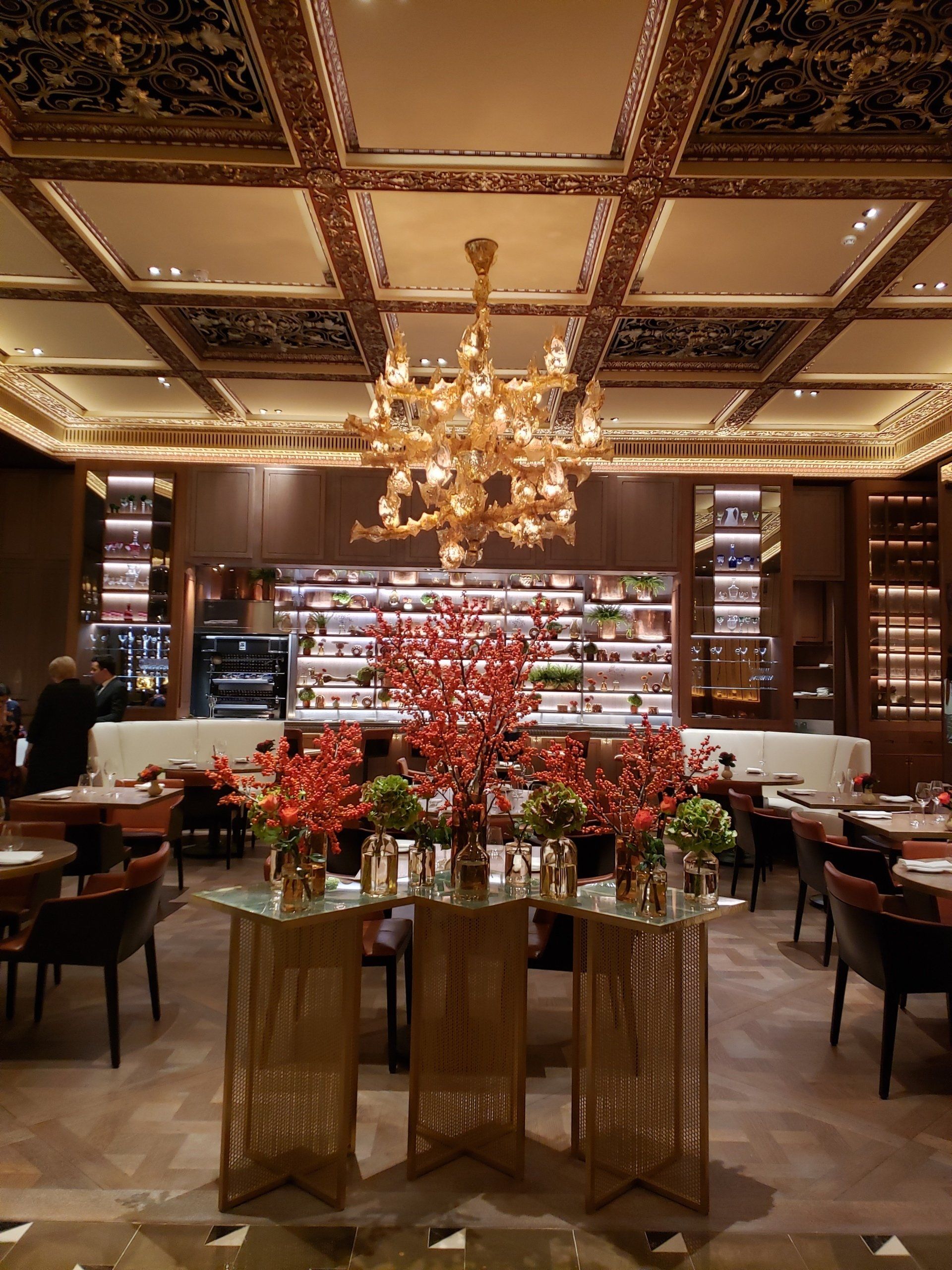 A restaurant with tables and chairs and a chandelier hanging from the ceiling.