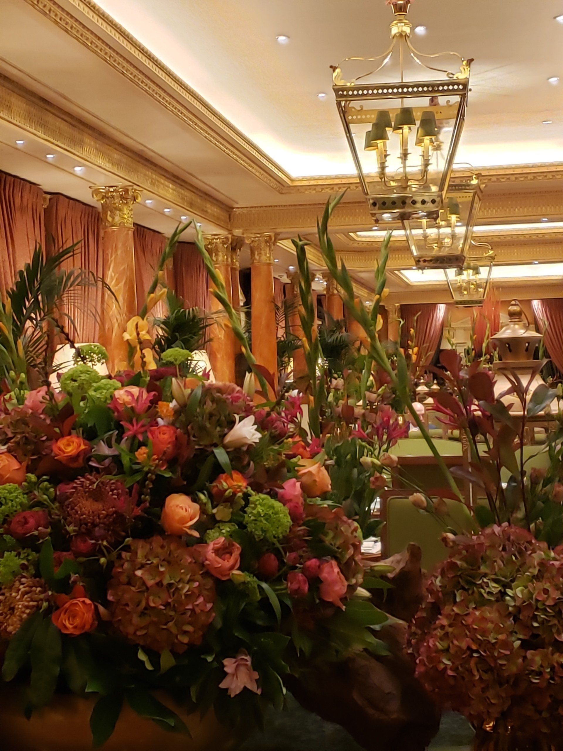 A large room filled with lots of flowers and a chandelier.