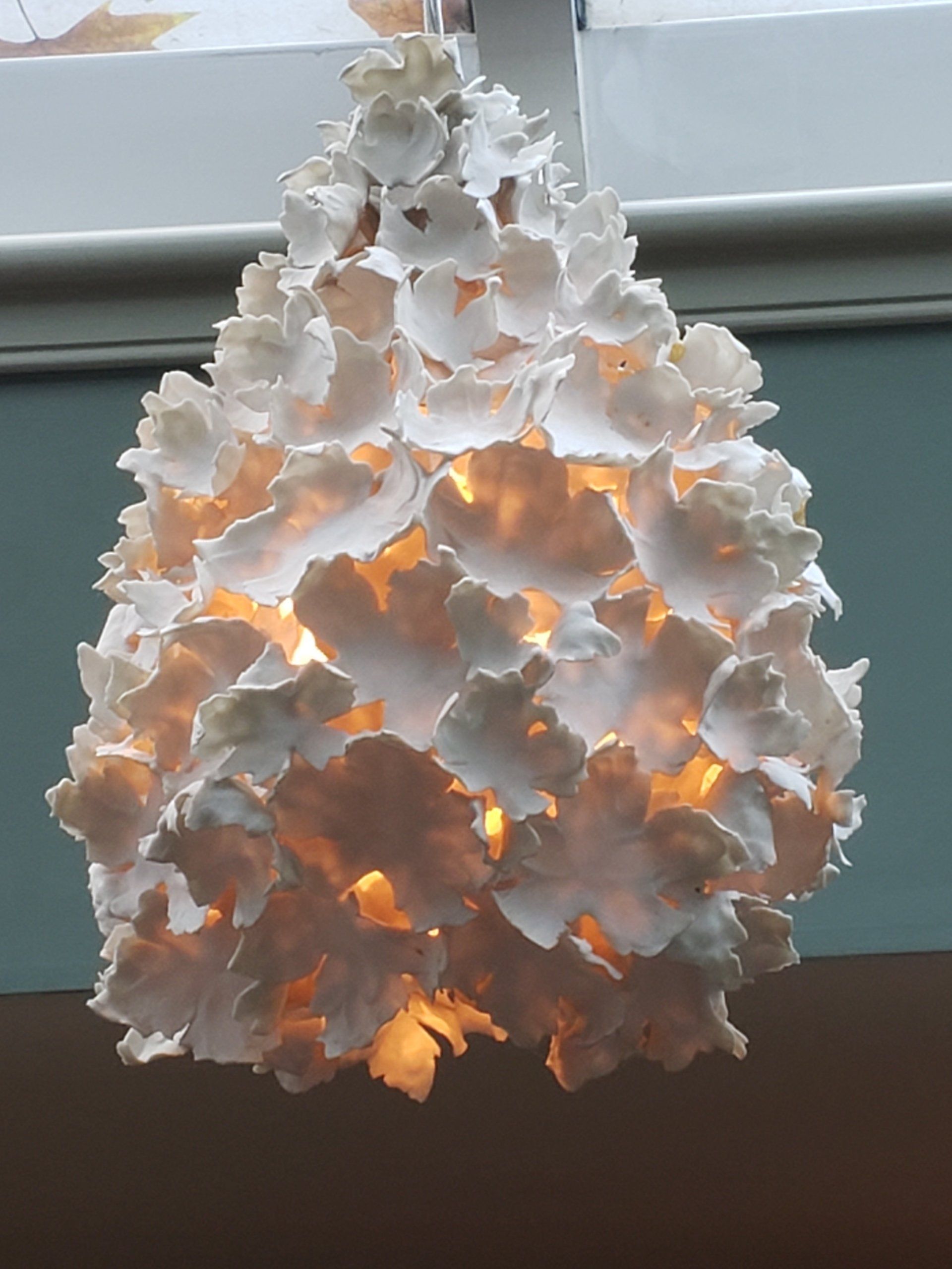 A lamp made out of white flowers is lit up