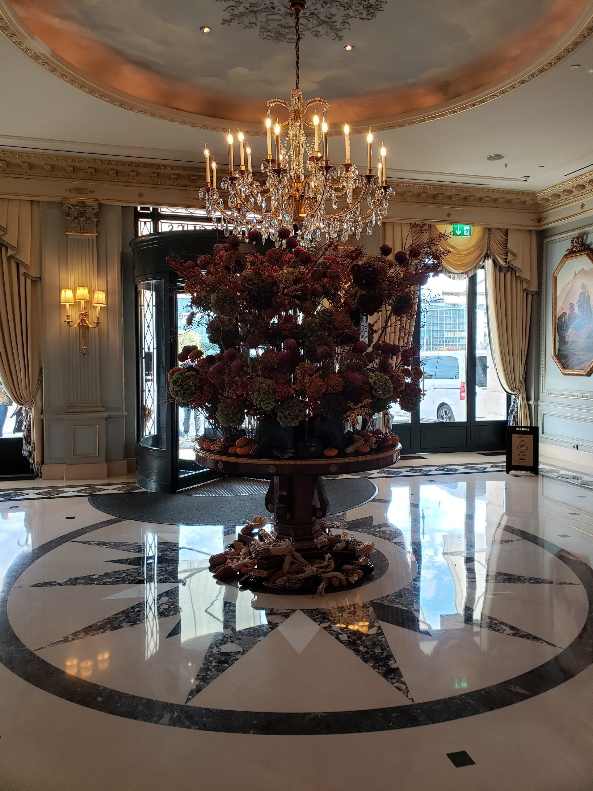 A large room with a chandelier and a table with flowers on it