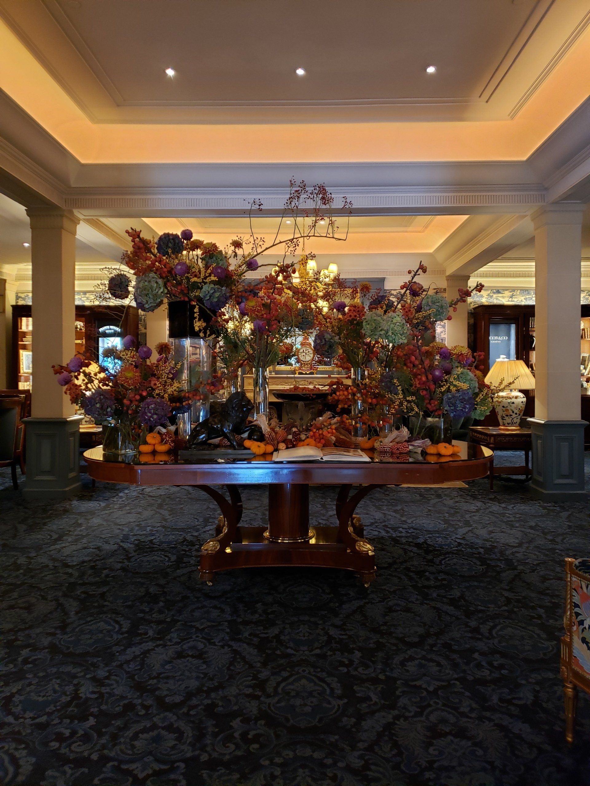 A large table with flowers on it in a hotel lobby