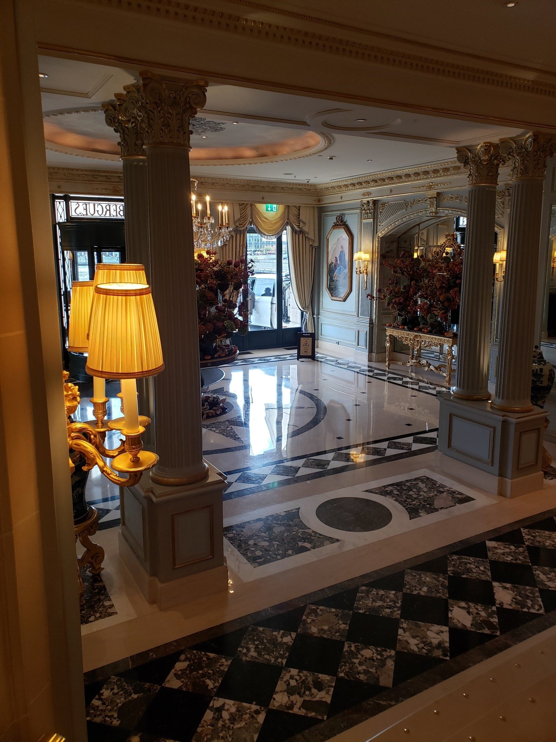 A hotel lobby with columns and a checkered floor