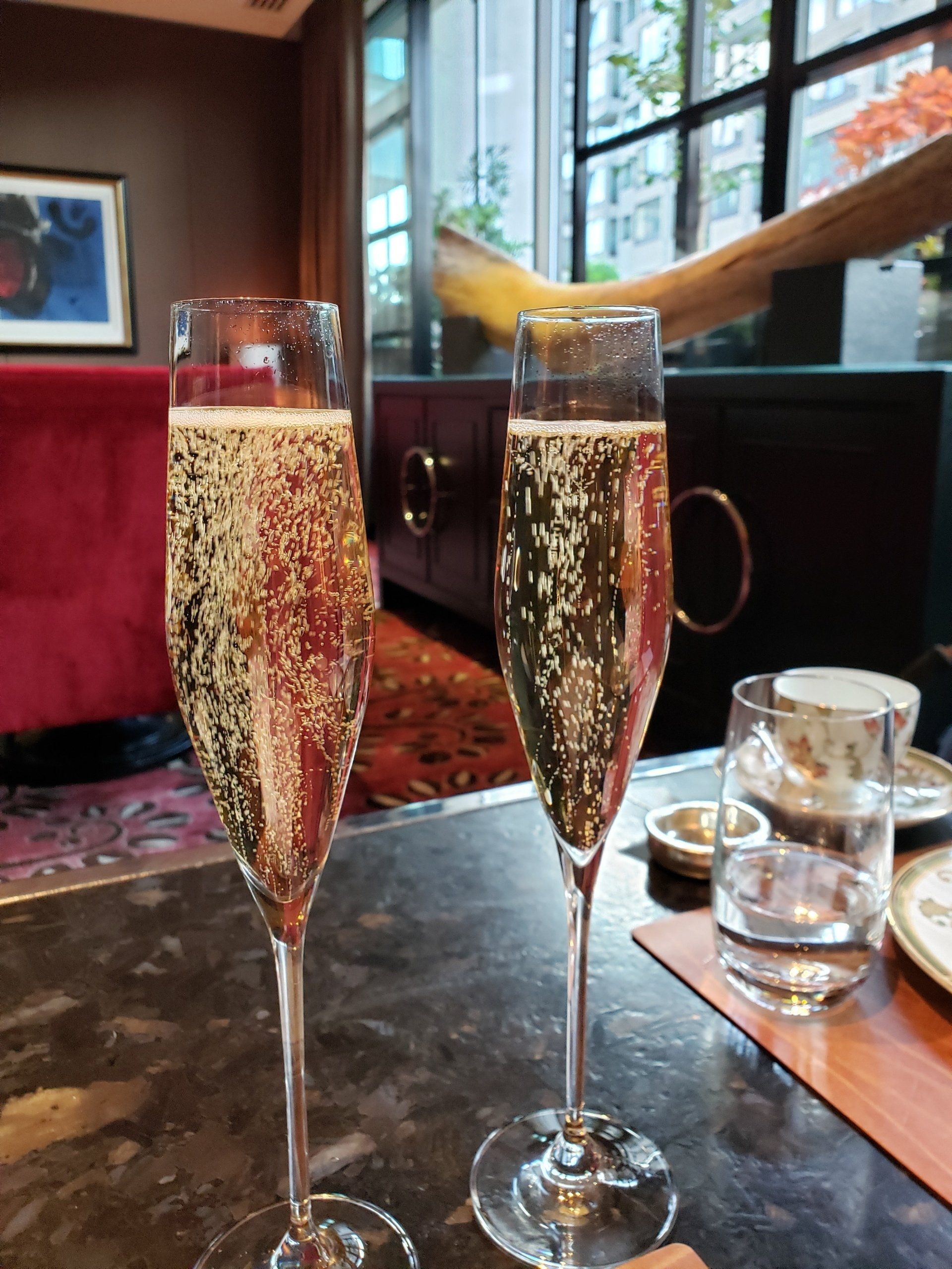 Two glasses of champagne are sitting on a table.