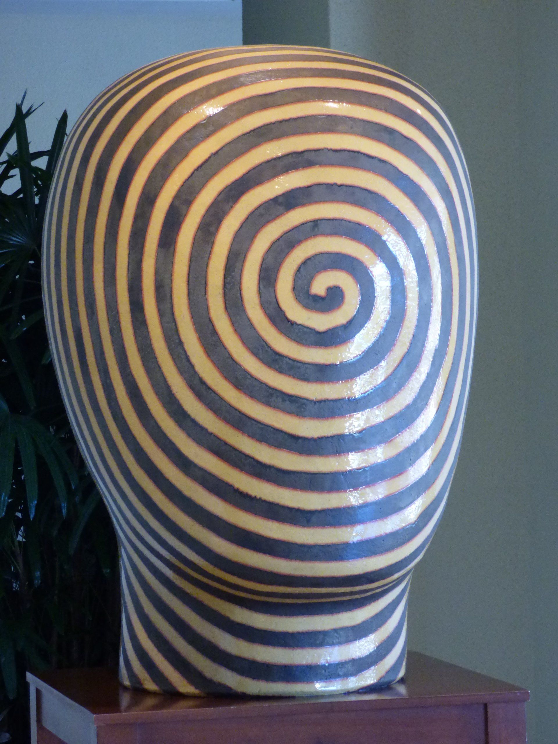 A statue of a head with a spiral design on it