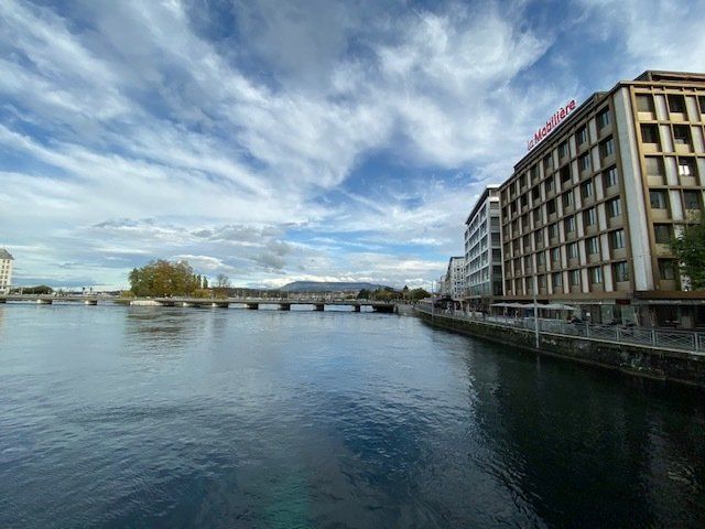 A bridge over a body of water with a building in the background