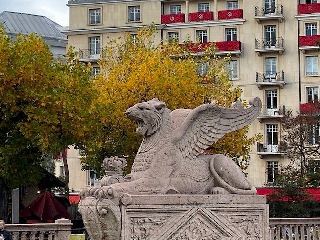A statue of a winged lion in front of a building