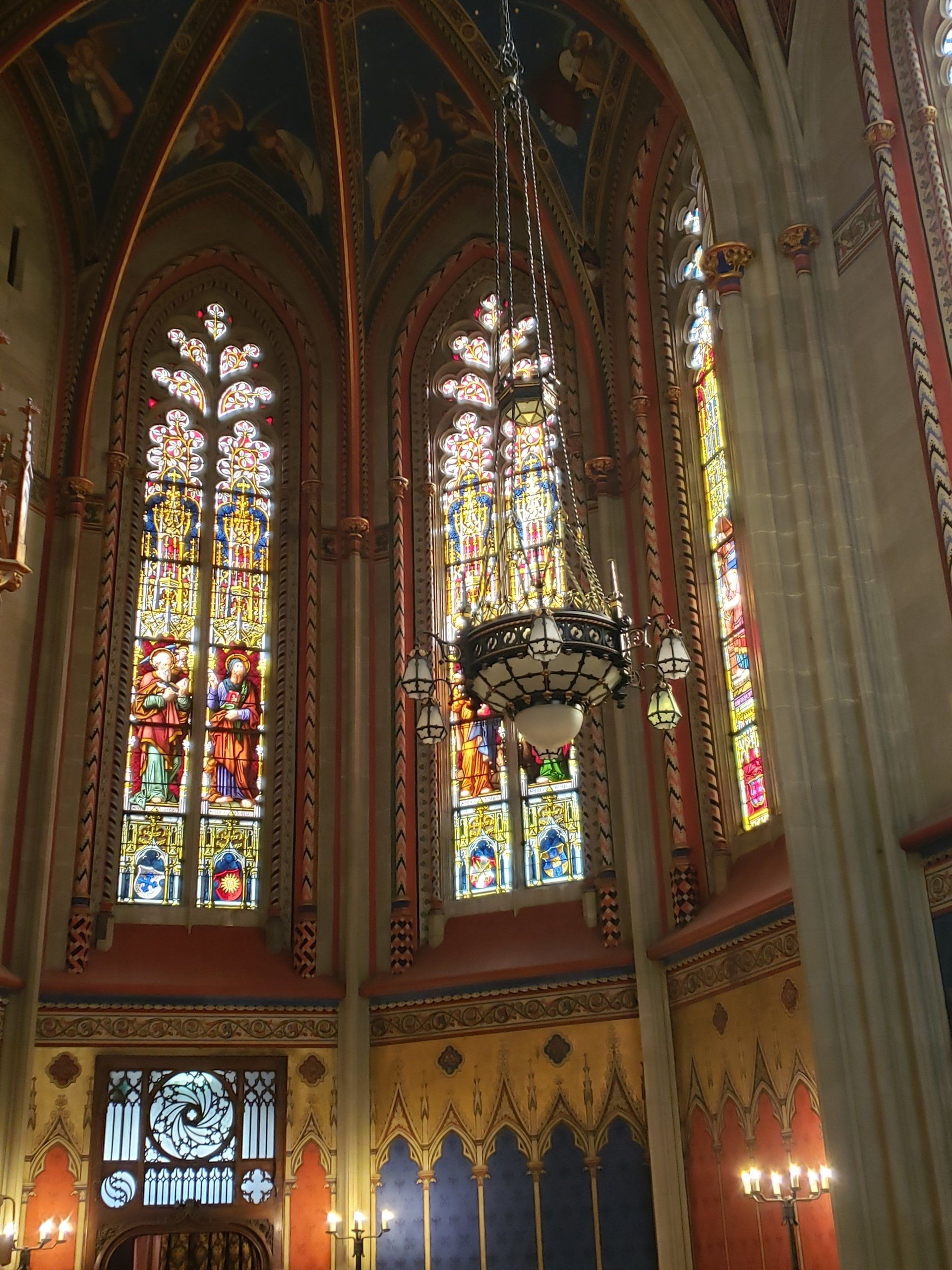 A church with stained glass windows and a chandelier hanging from the ceiling