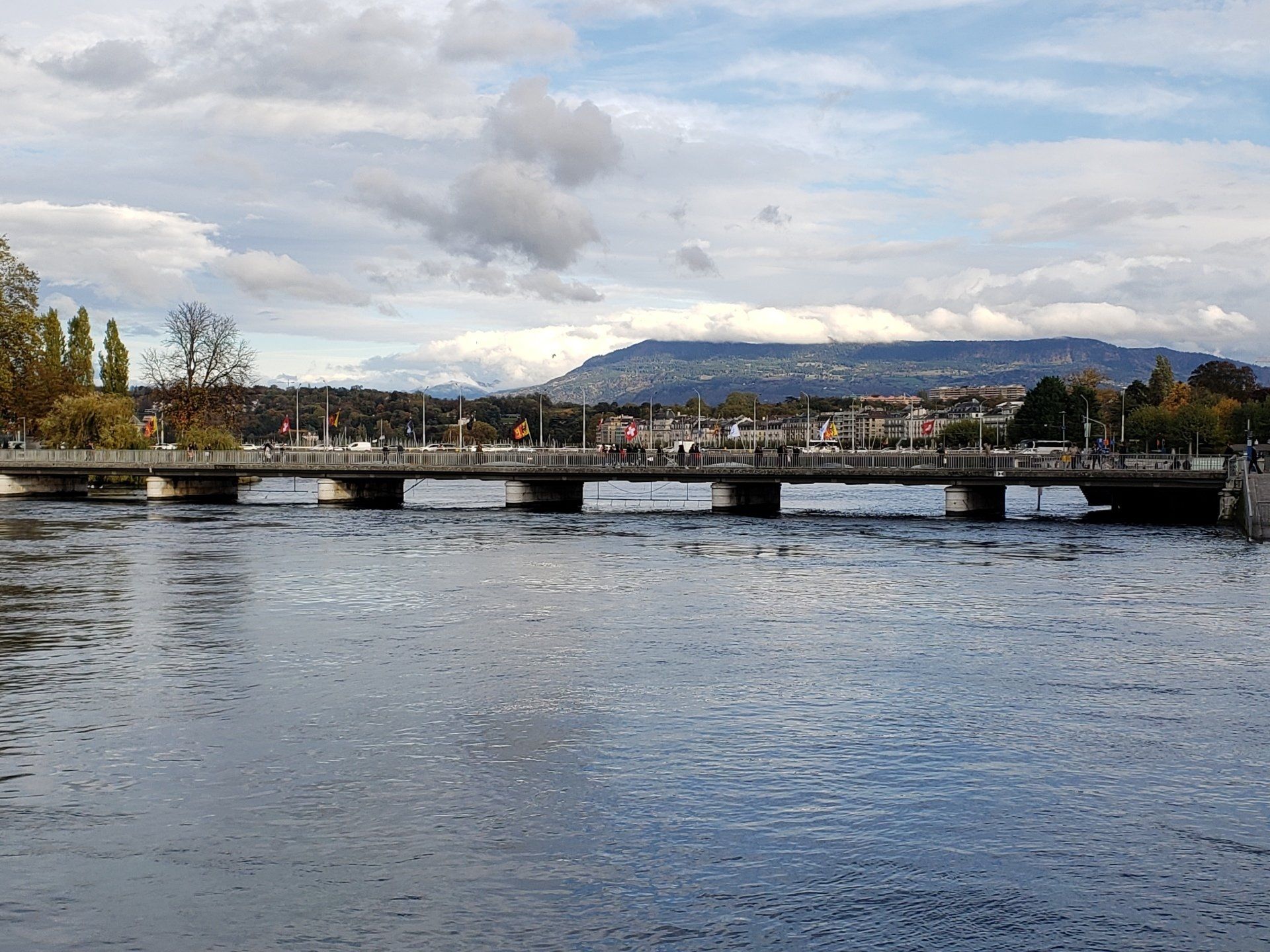 A bridge over a body of water with a mountain in the background.