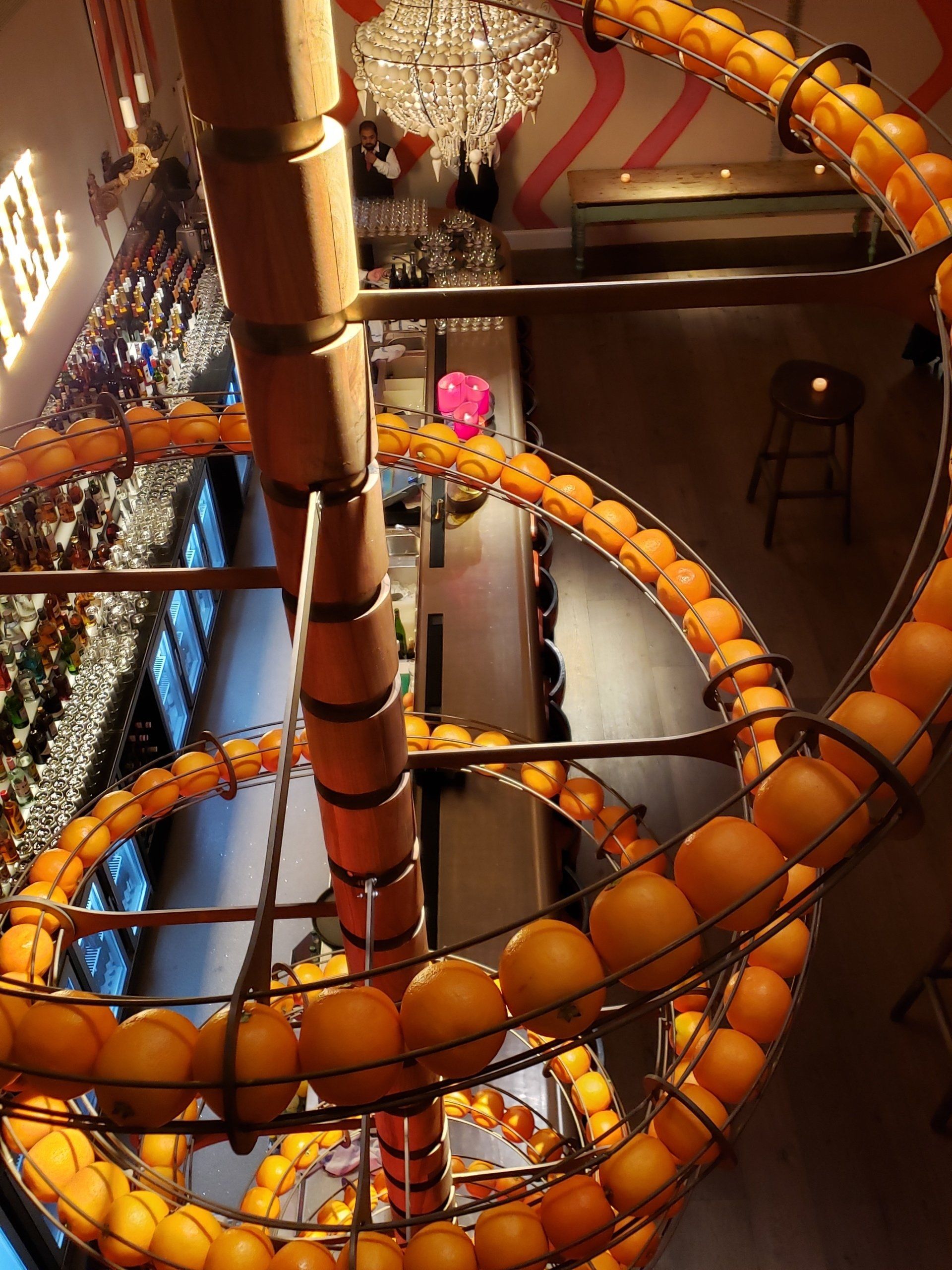 A spiral of oranges hanging from the ceiling of a restaurant