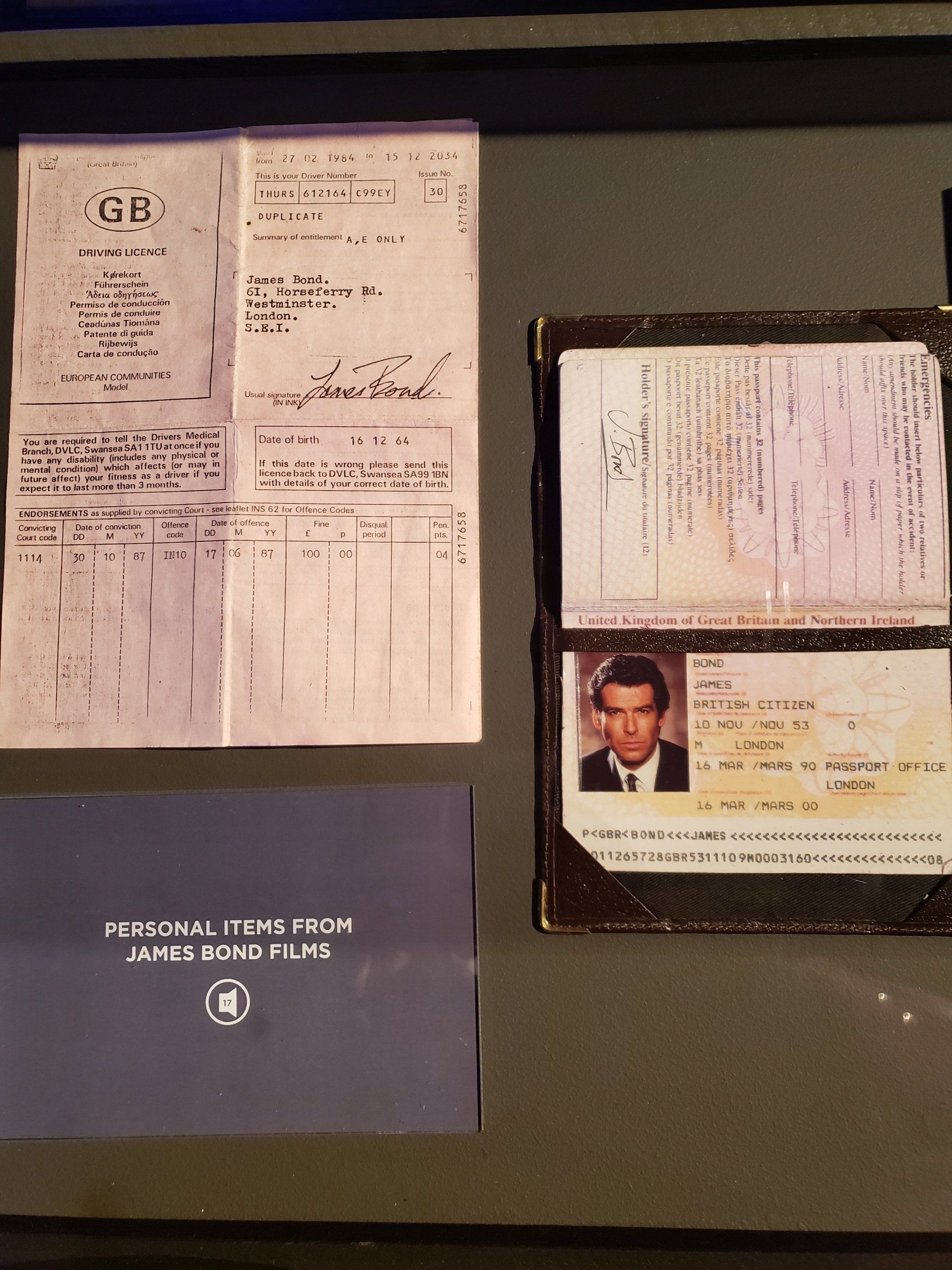 A james bond film memorabilia display includes a receipt and a passport