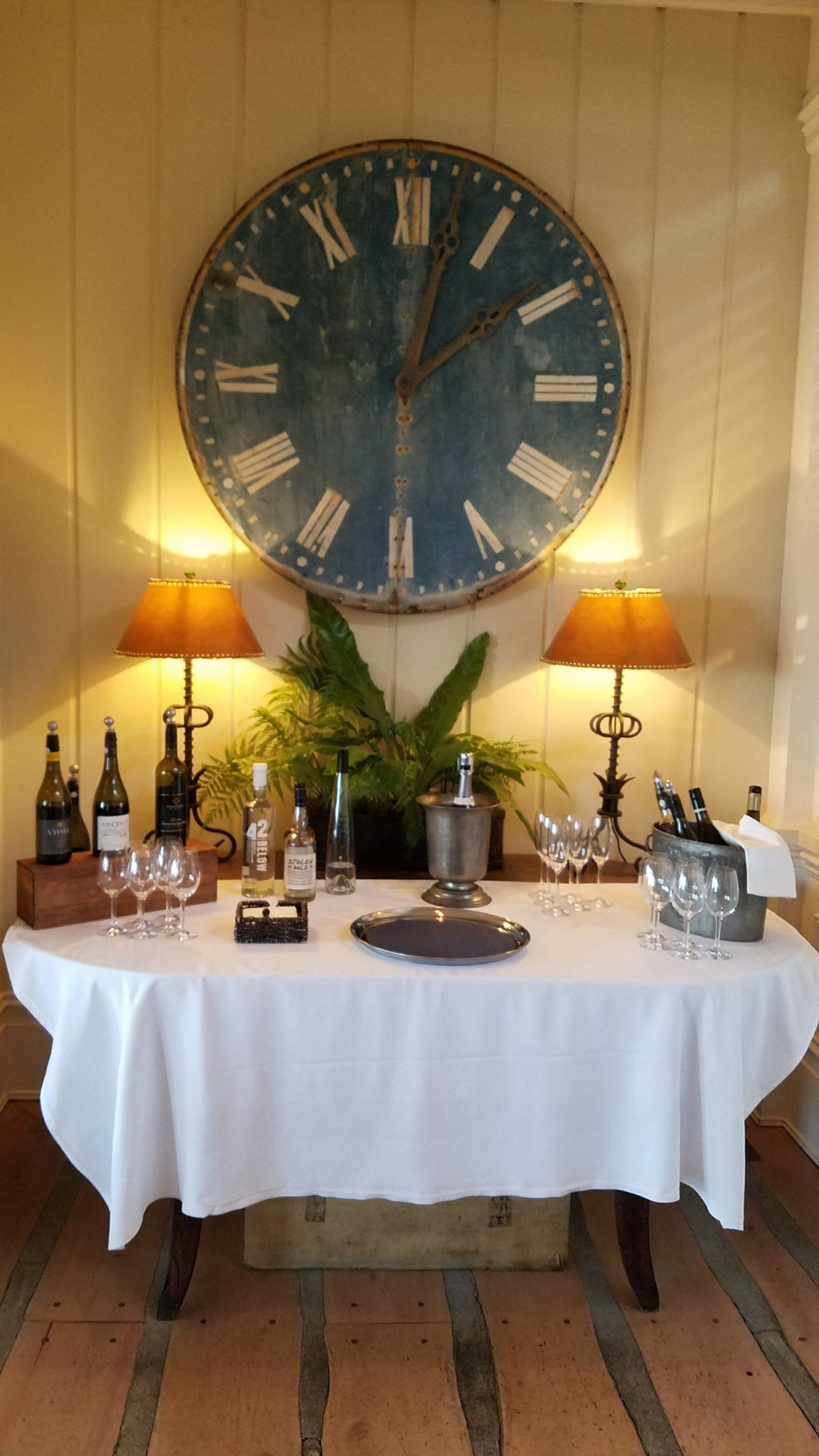 A table with a white tablecloth and a clock on the wall.