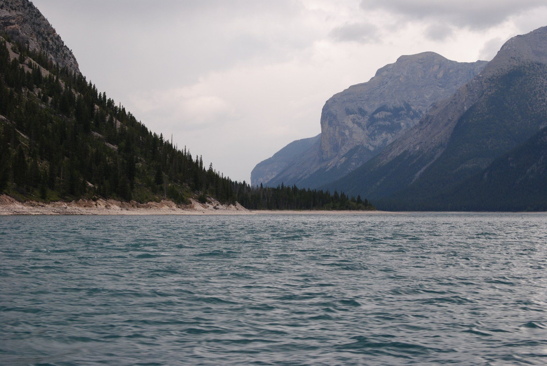 A lake with mountains in the background and trees on the shore