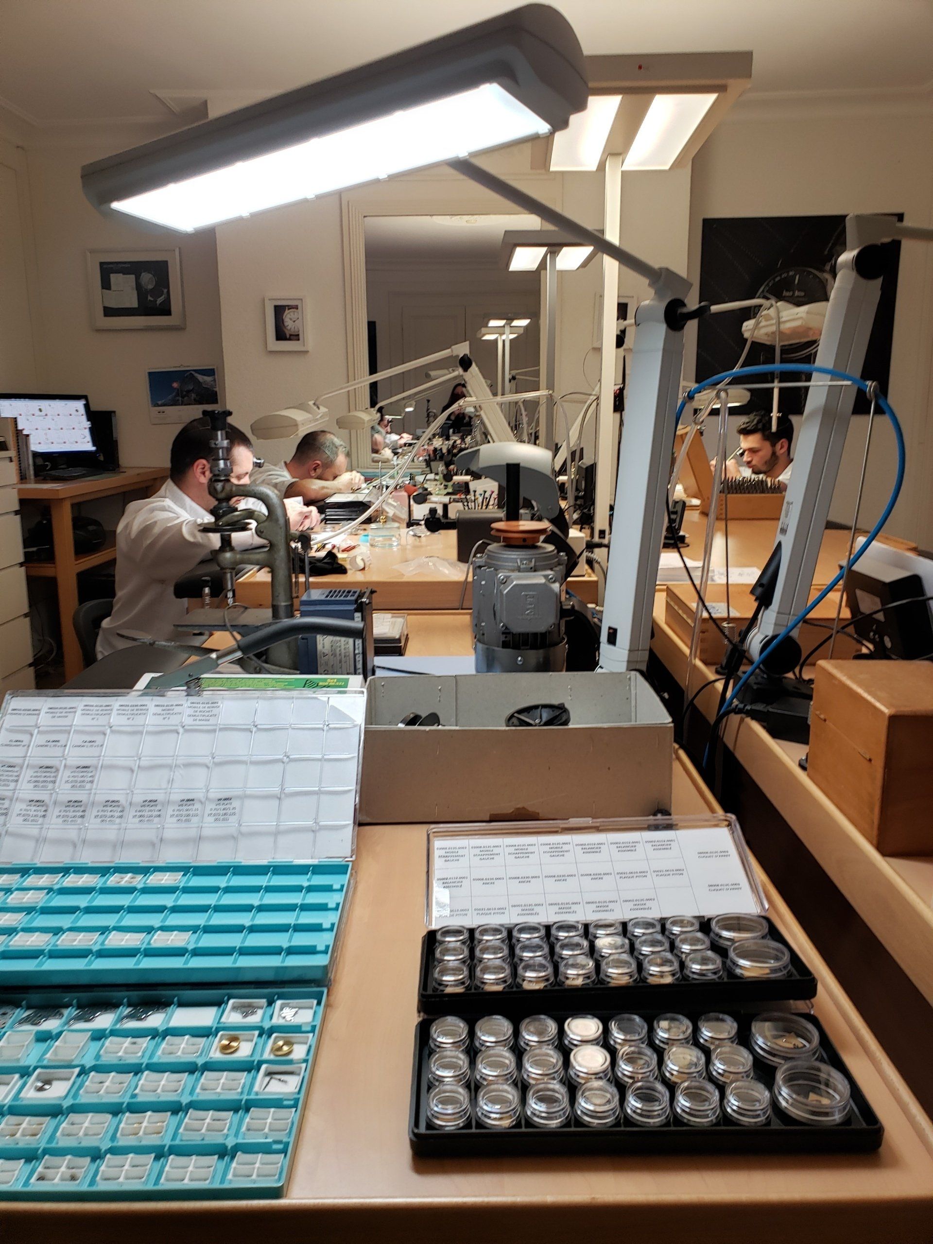A group of men are working on watches in a factory.