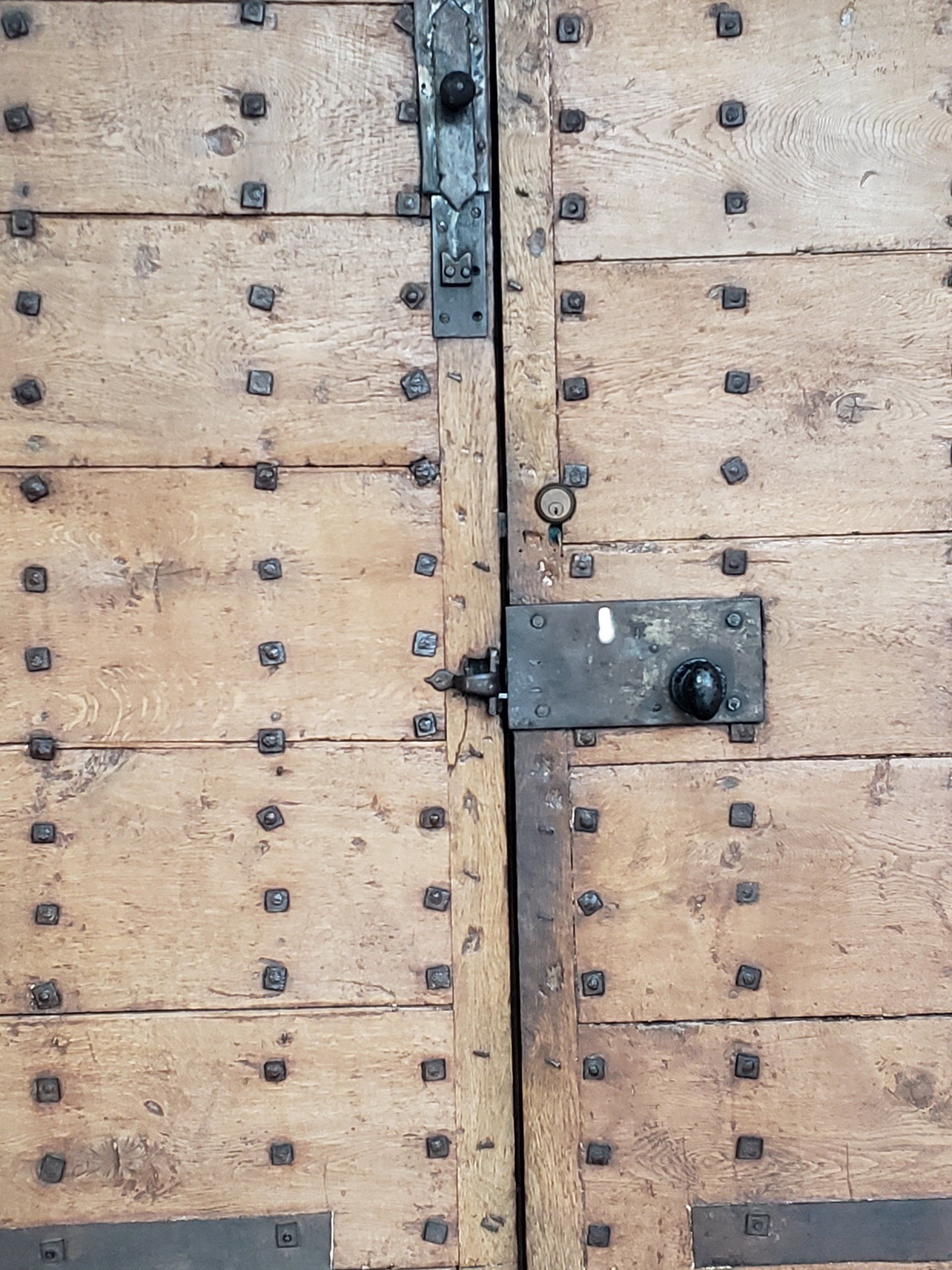 A close up of a wooden door with a metal latch