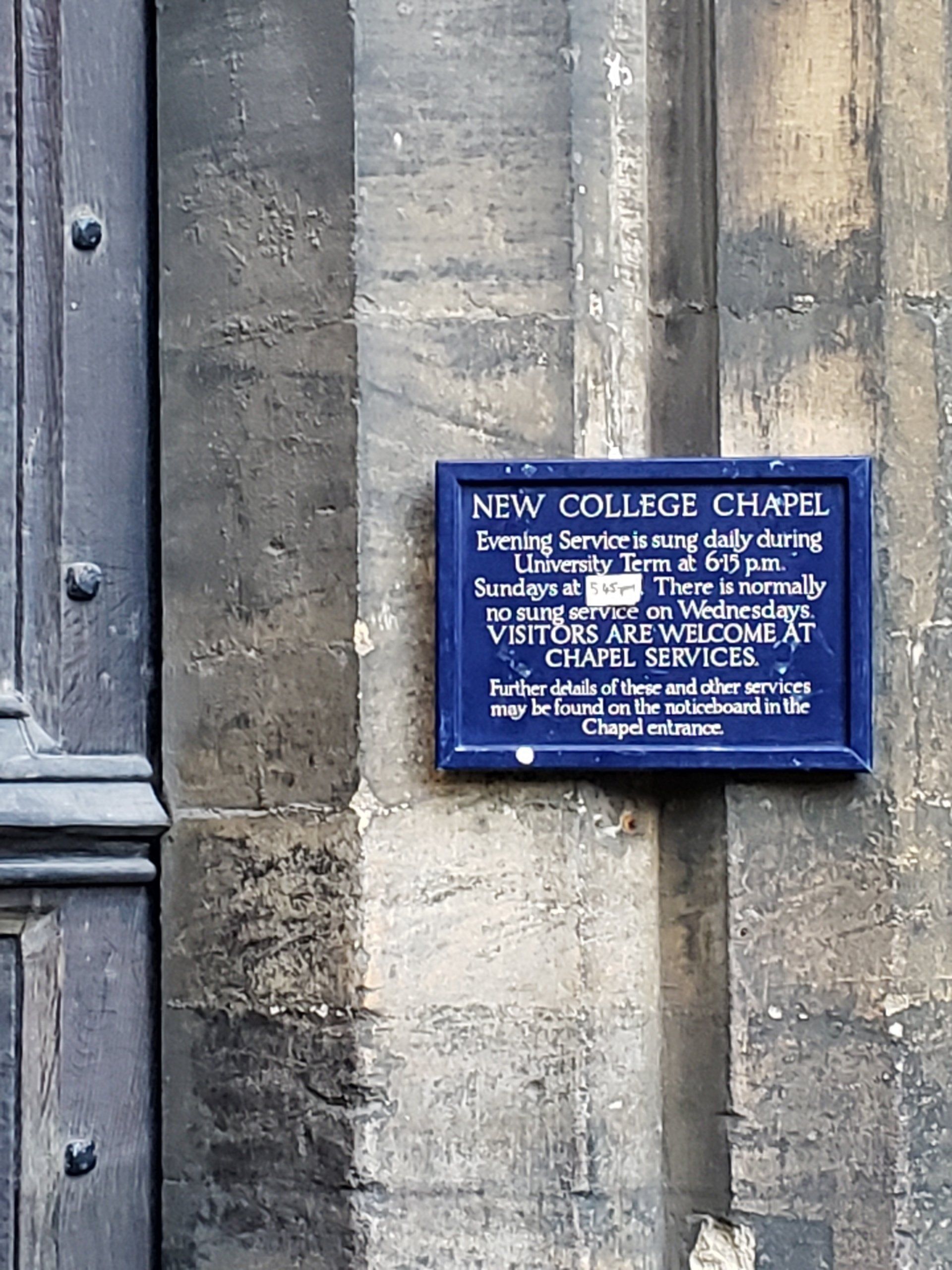 A sign on the side of a building that says new college chapel