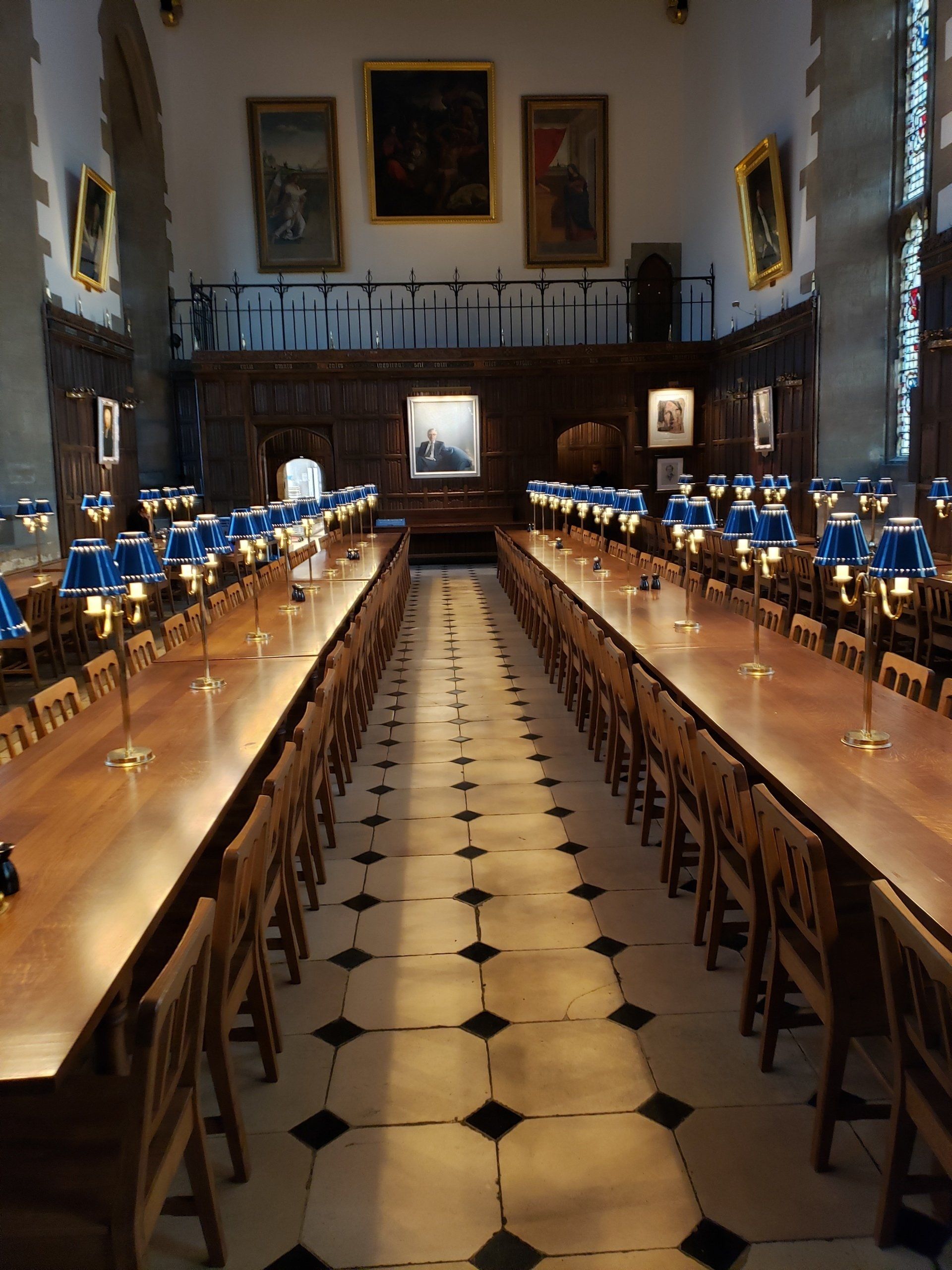 A long dining room with tables and chairs and lamps