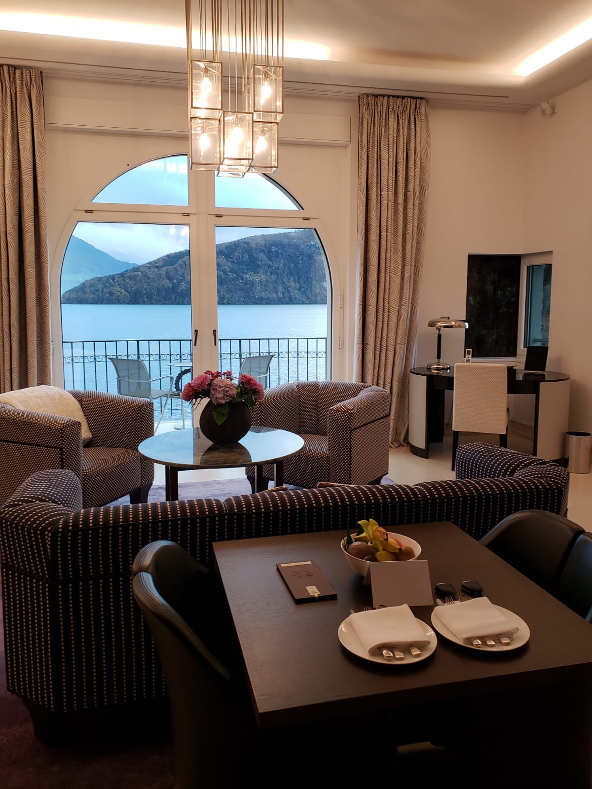 A living room with a table and chairs and a view of a lake