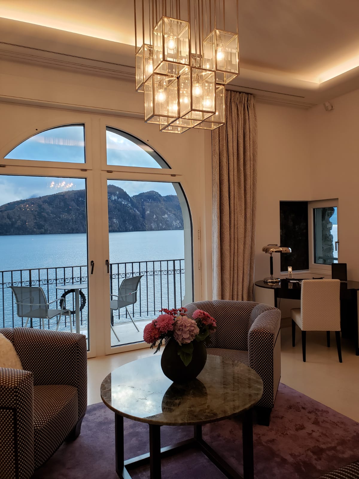 A living room with a view of a lake and mountains