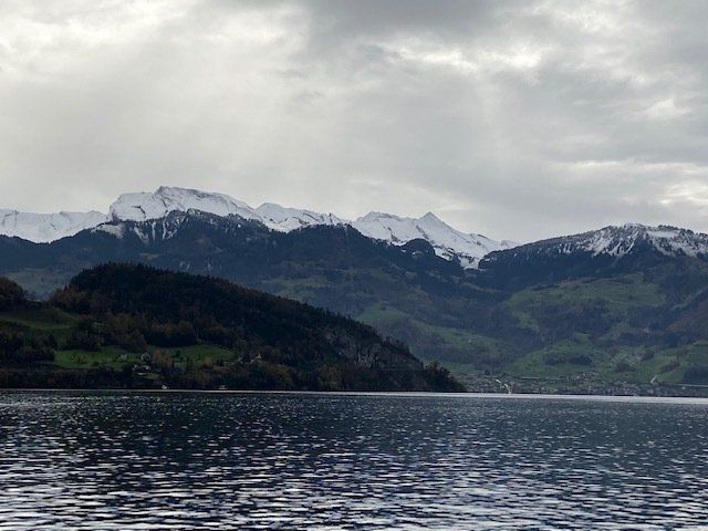 A lake with mountains in the background on a cloudy day