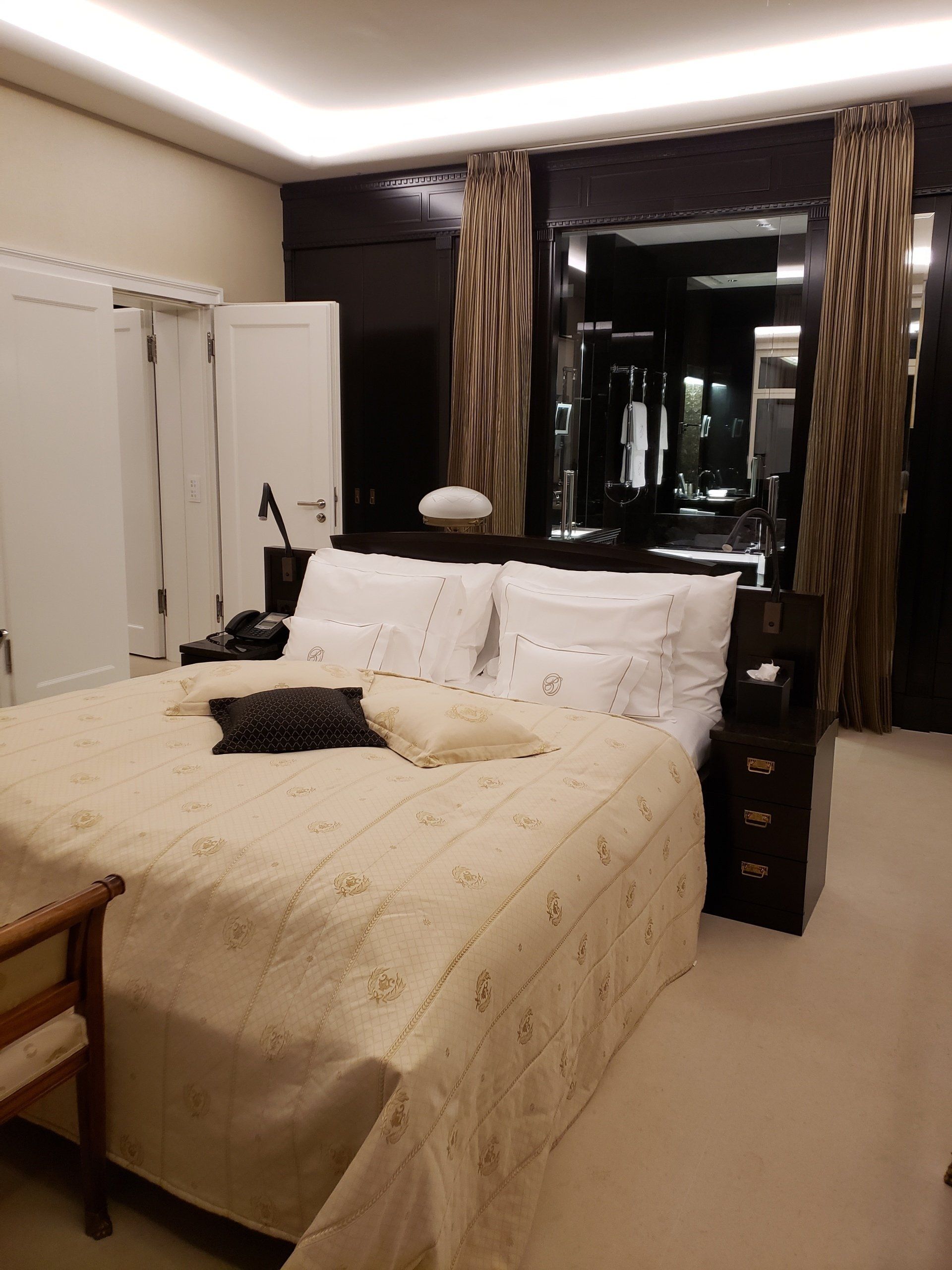 A bedroom with a large bed and a chair
