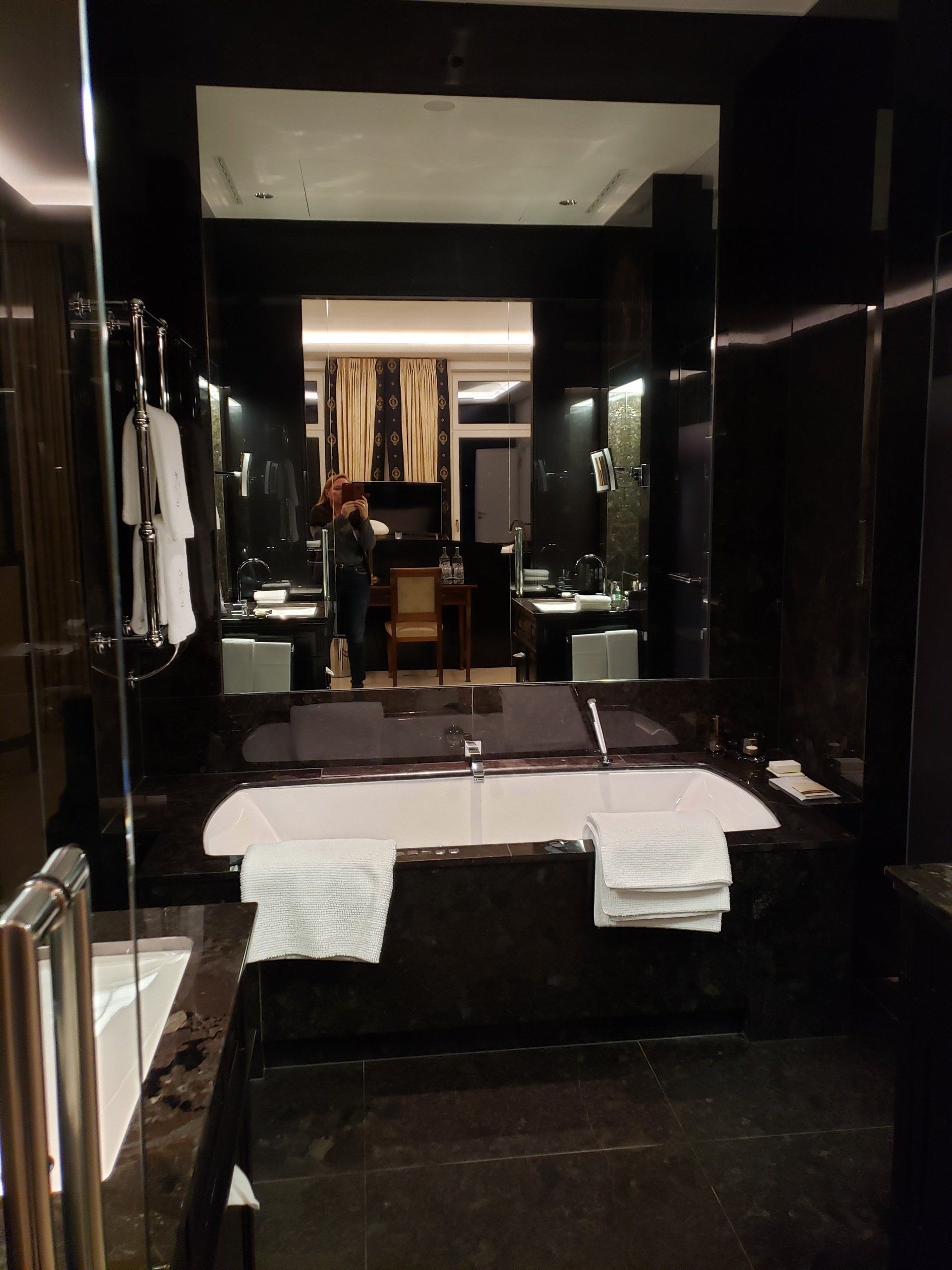 A bathroom with a large tub and a large mirror