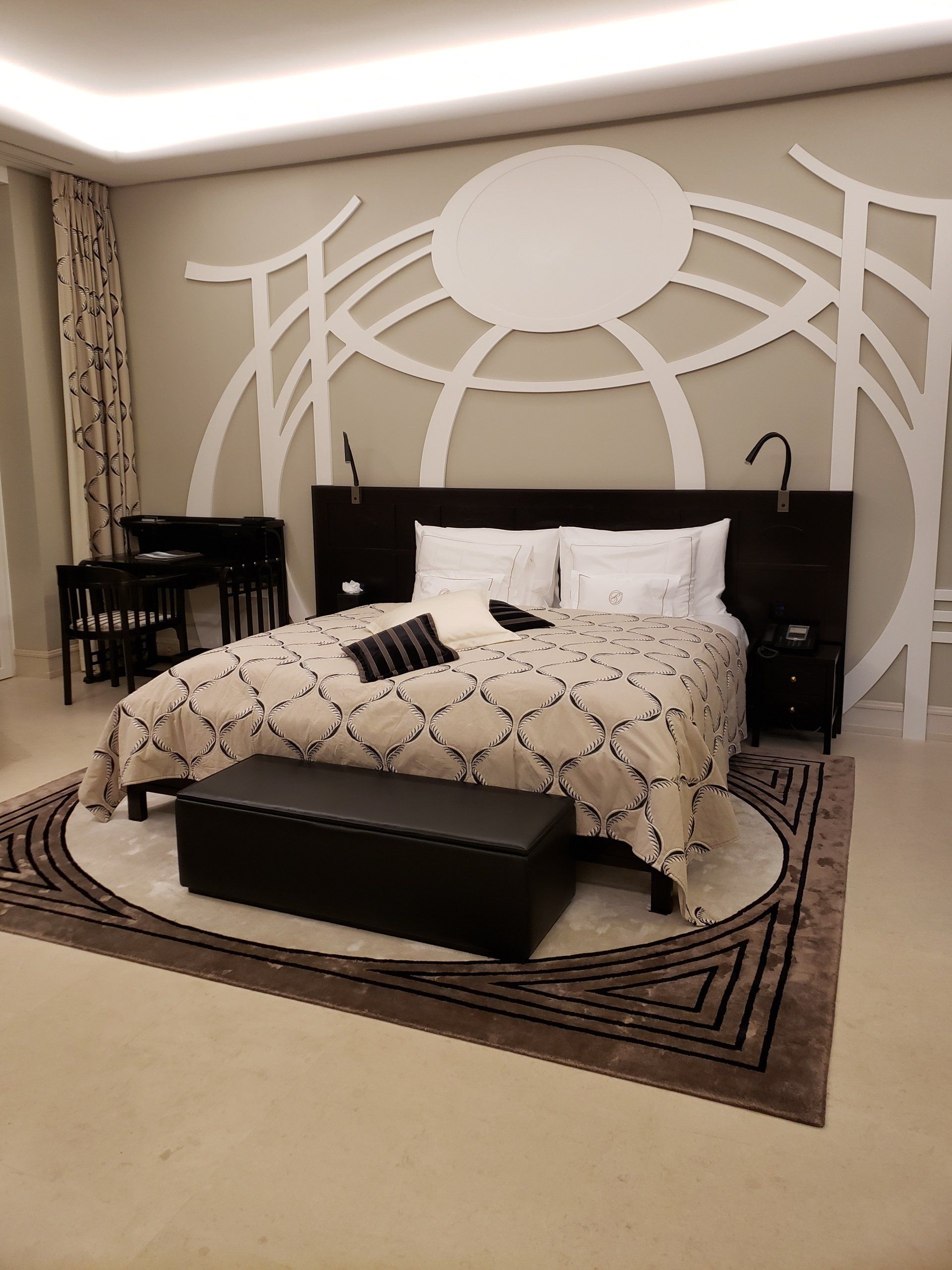 A bedroom with a large bed and a bench