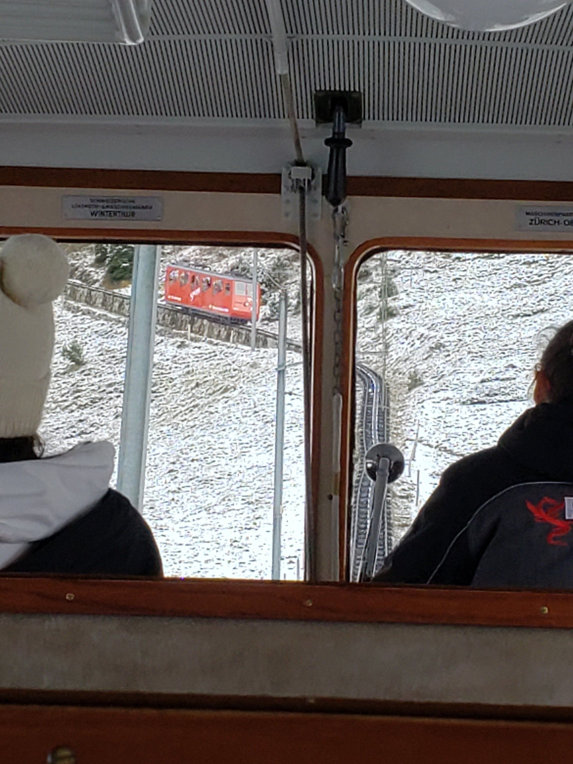 Two people are sitting on a bus looking out the window