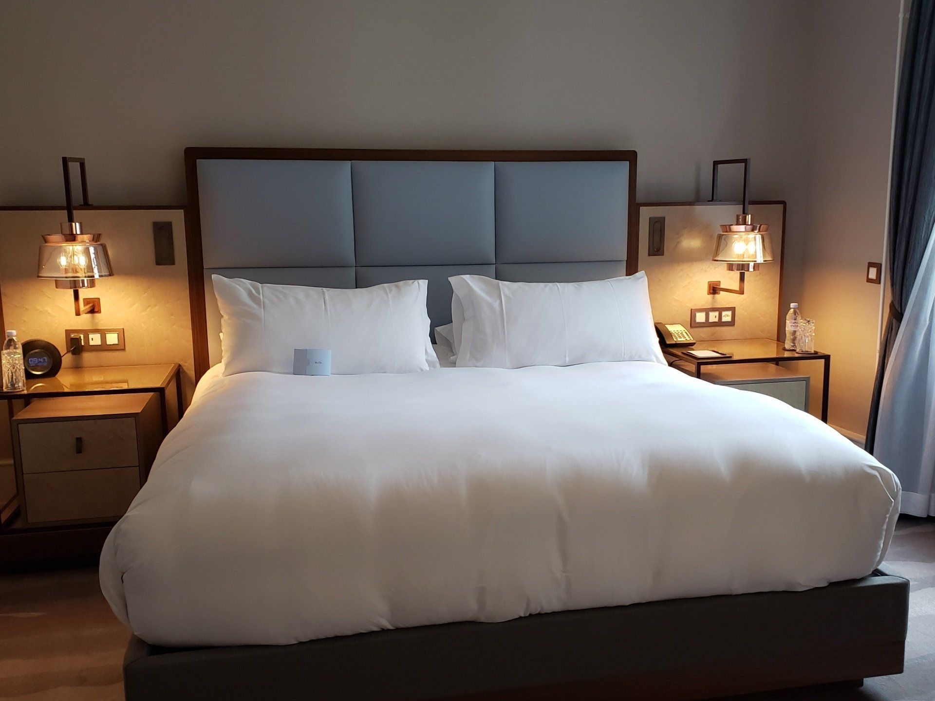 A hotel room with a king size bed and two nightstands
