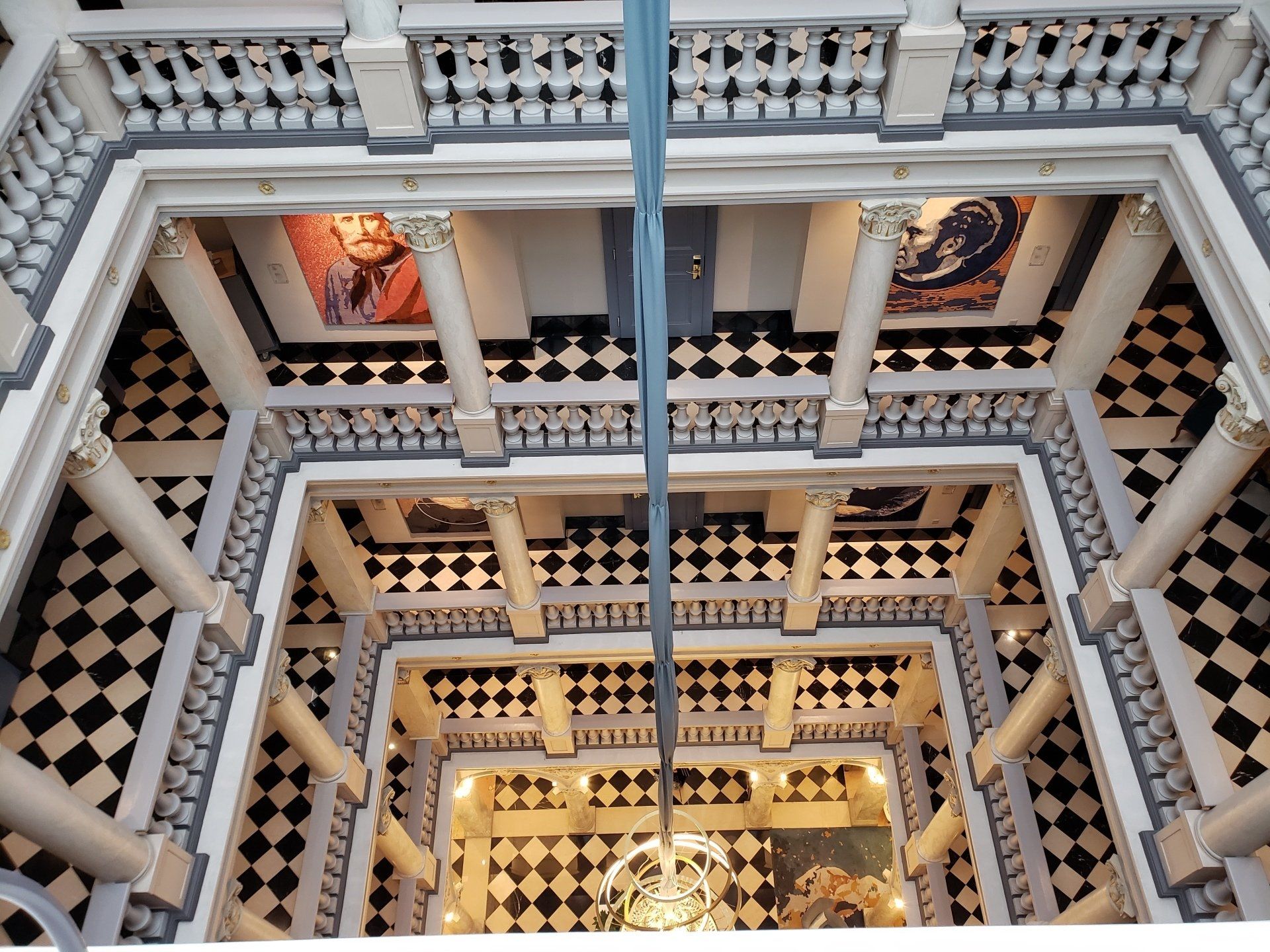 The inside of a building with columns and a checkered floor
