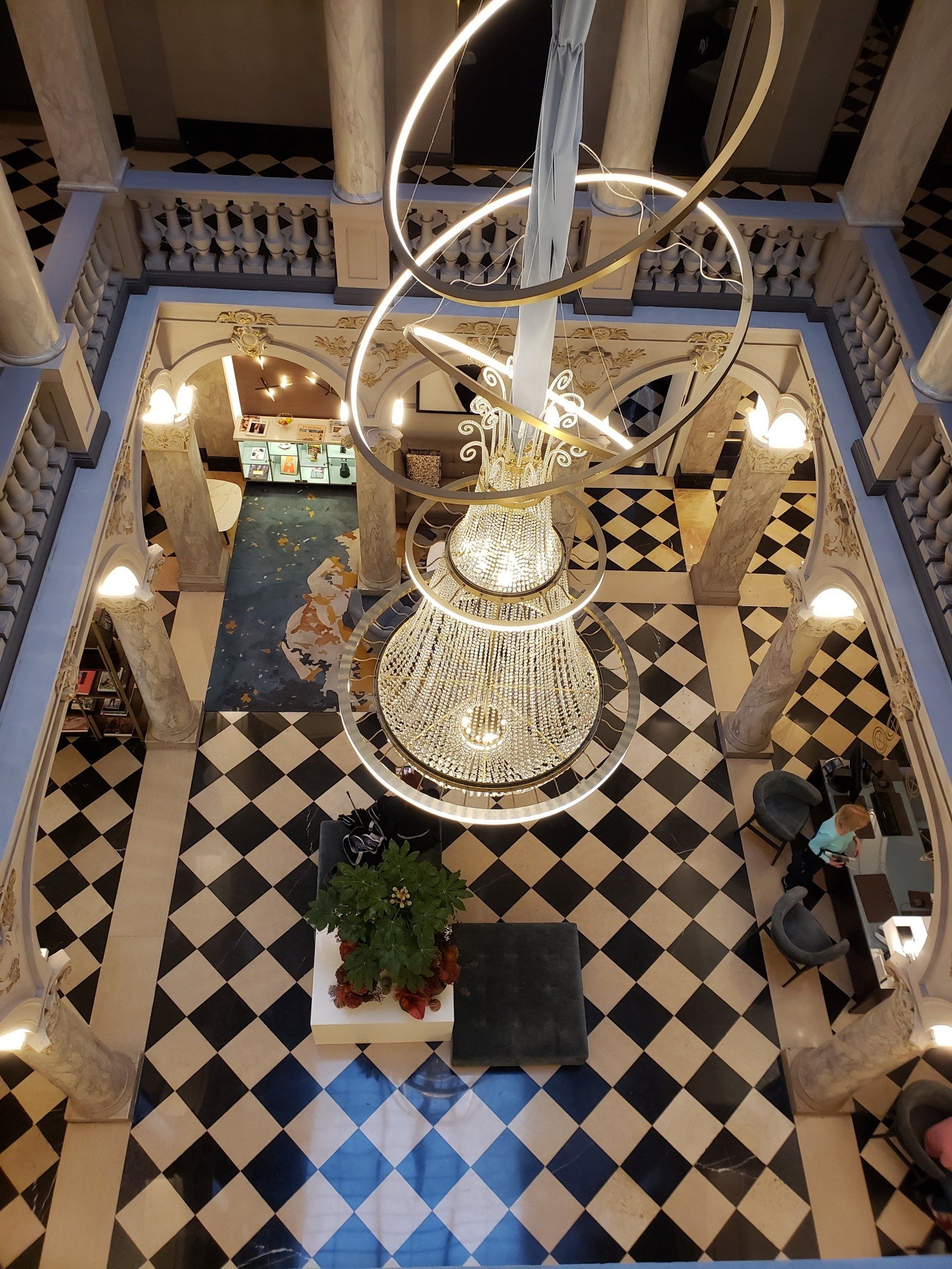 An aerial view of a hotel lobby with a large chandelier hanging from the ceiling
