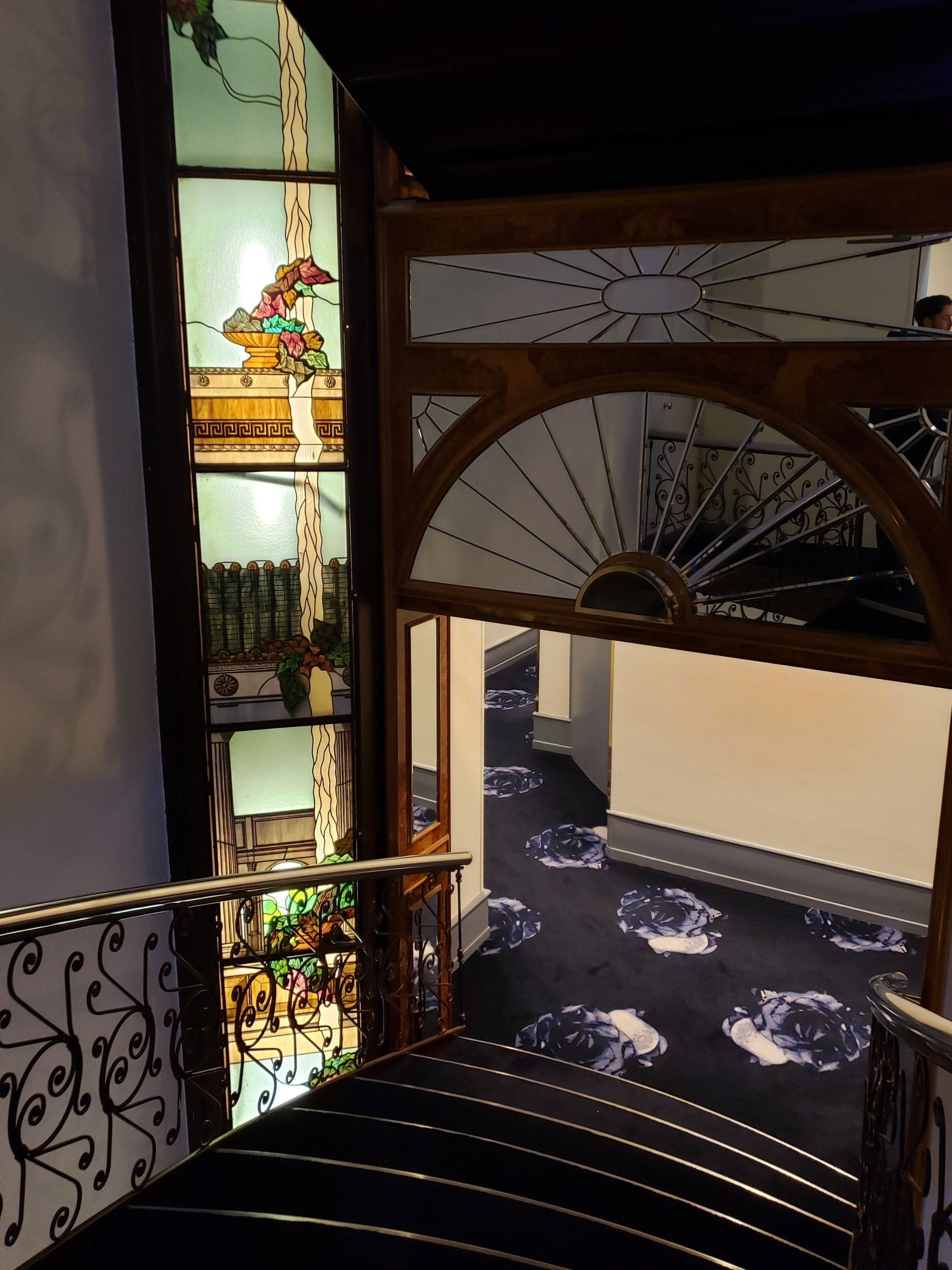 A staircase in a building with a stained glass window