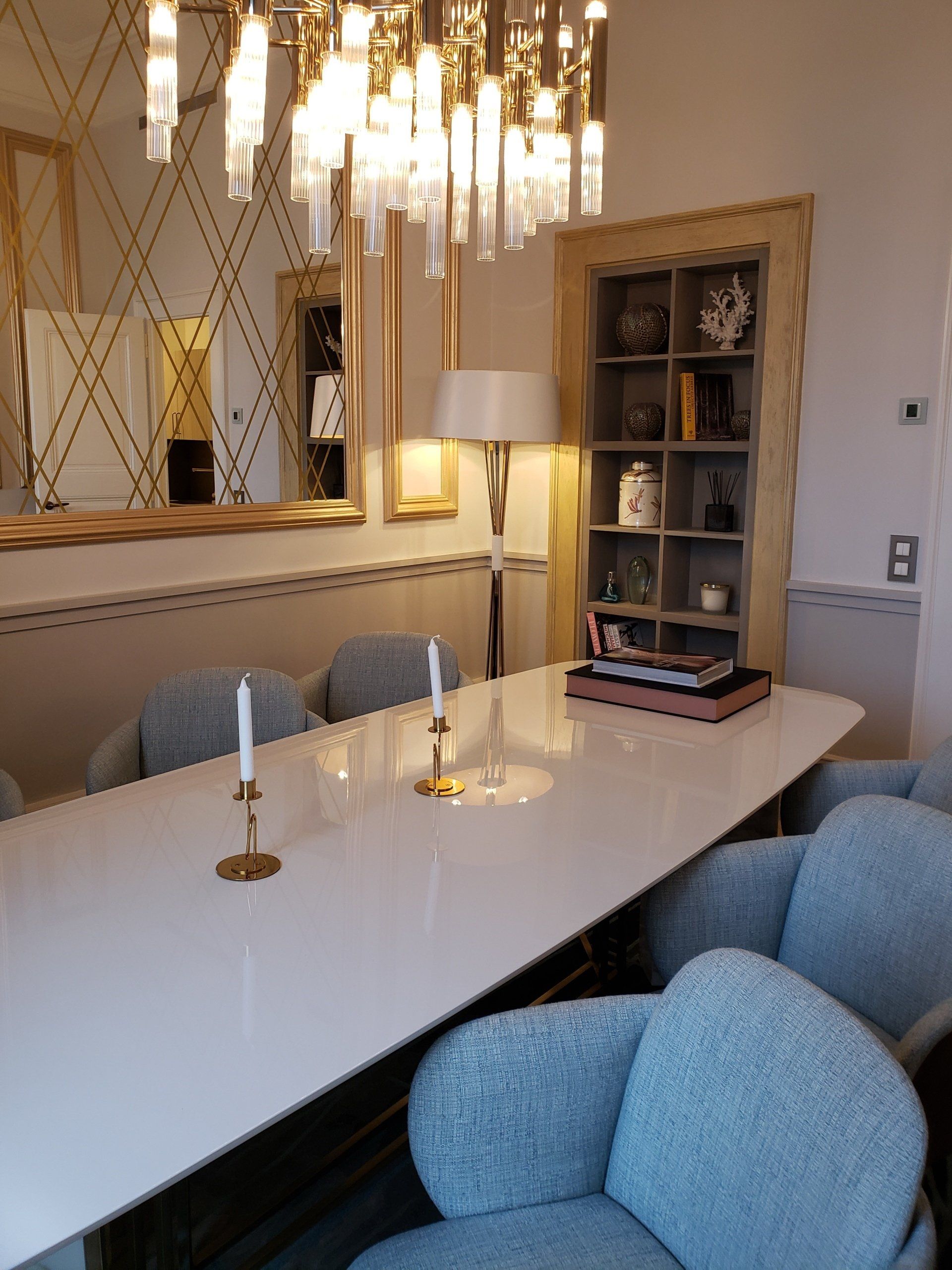 A dining room with a long white table and blue chairs