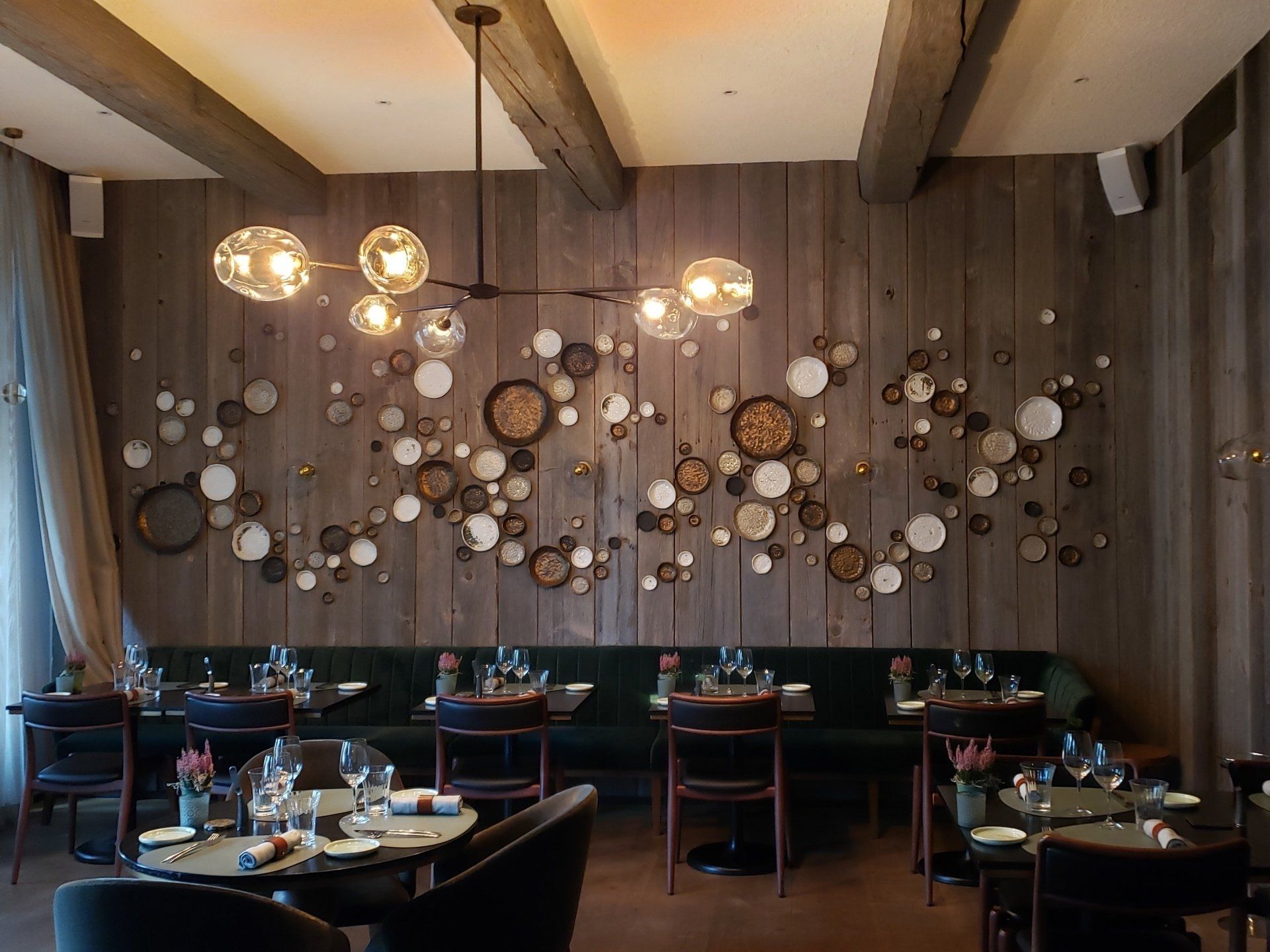 A restaurant with tables and chairs and a wooden wall