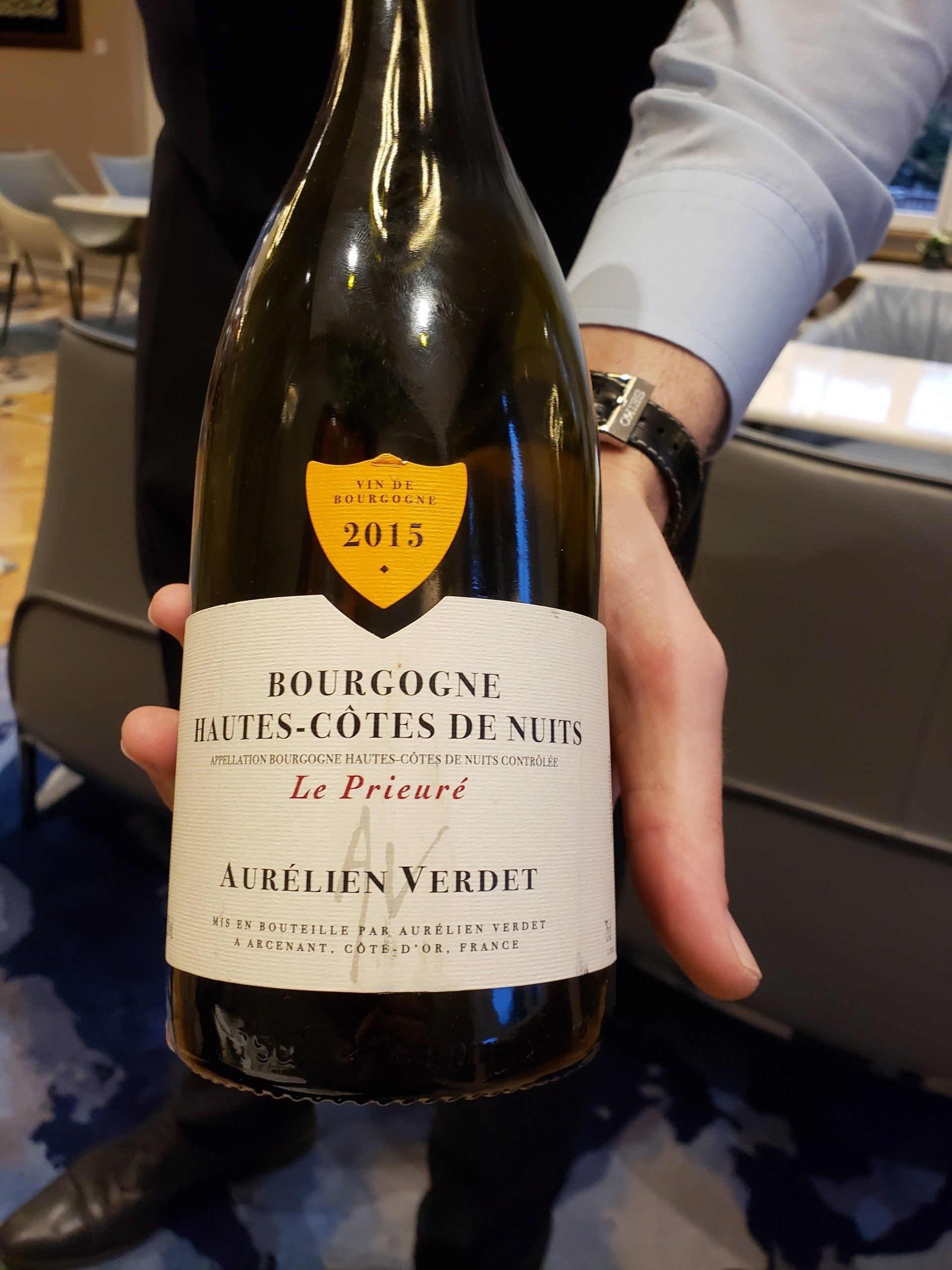 A person is holding a bottle of bourgogne wine from 2013