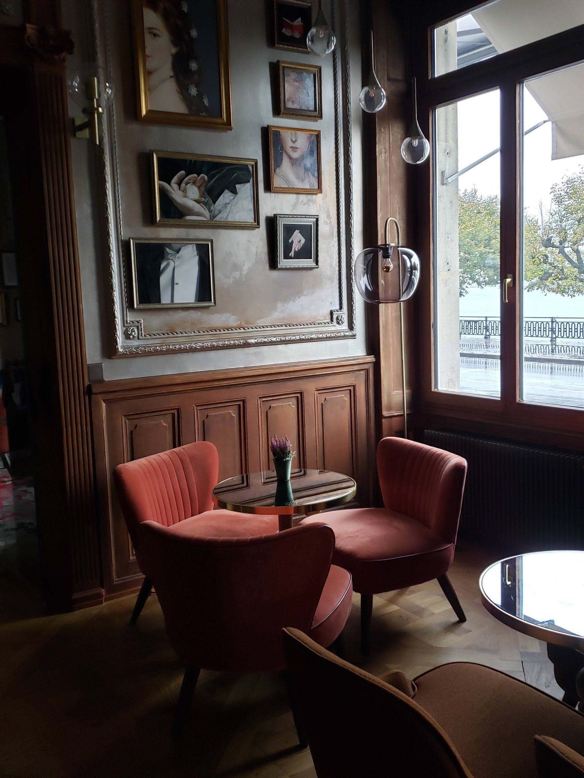 A room with a lot of chairs and tables and paintings on the wall