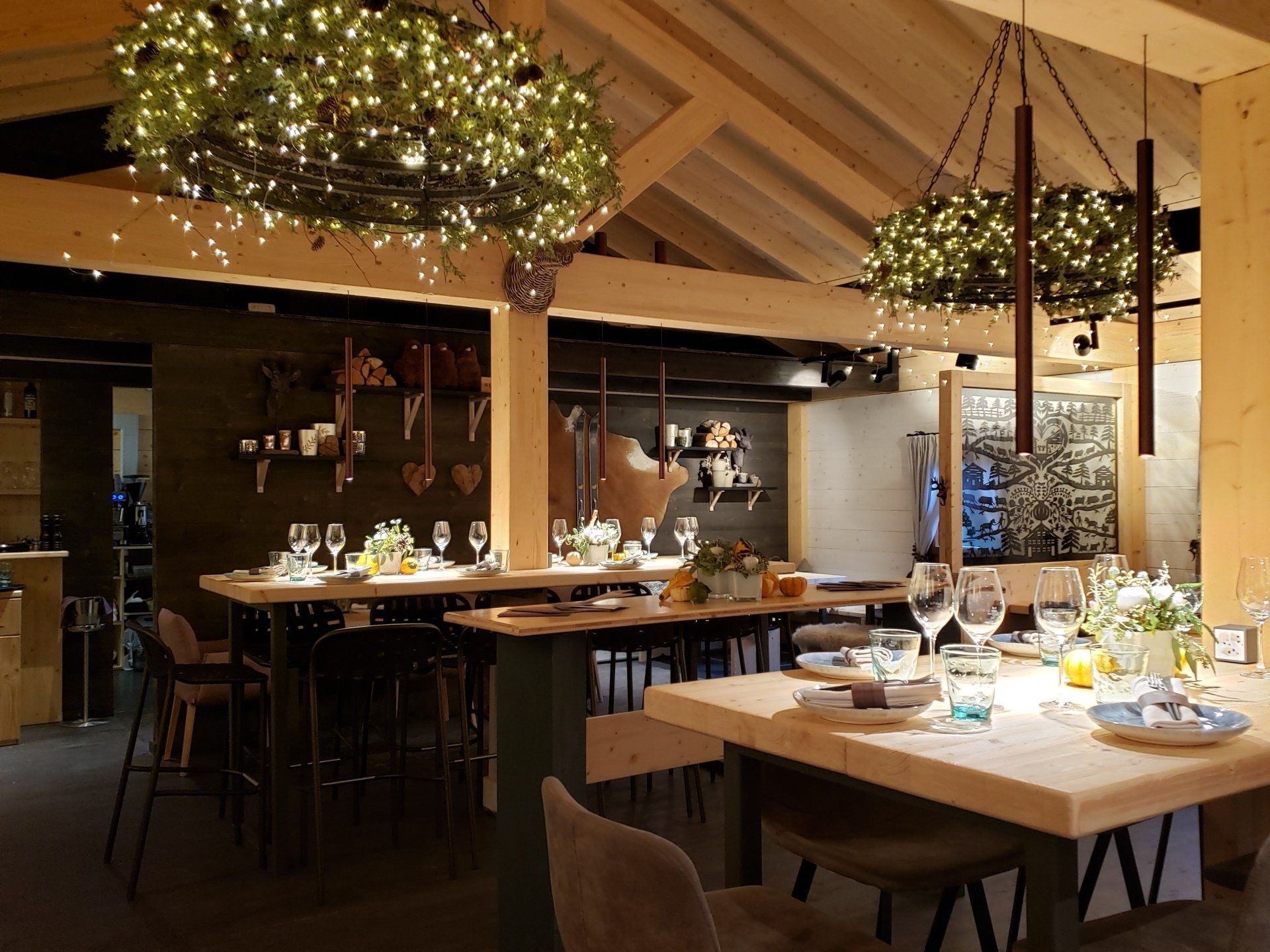 A restaurant with tables and chairs and a chandelier hanging from the ceiling.