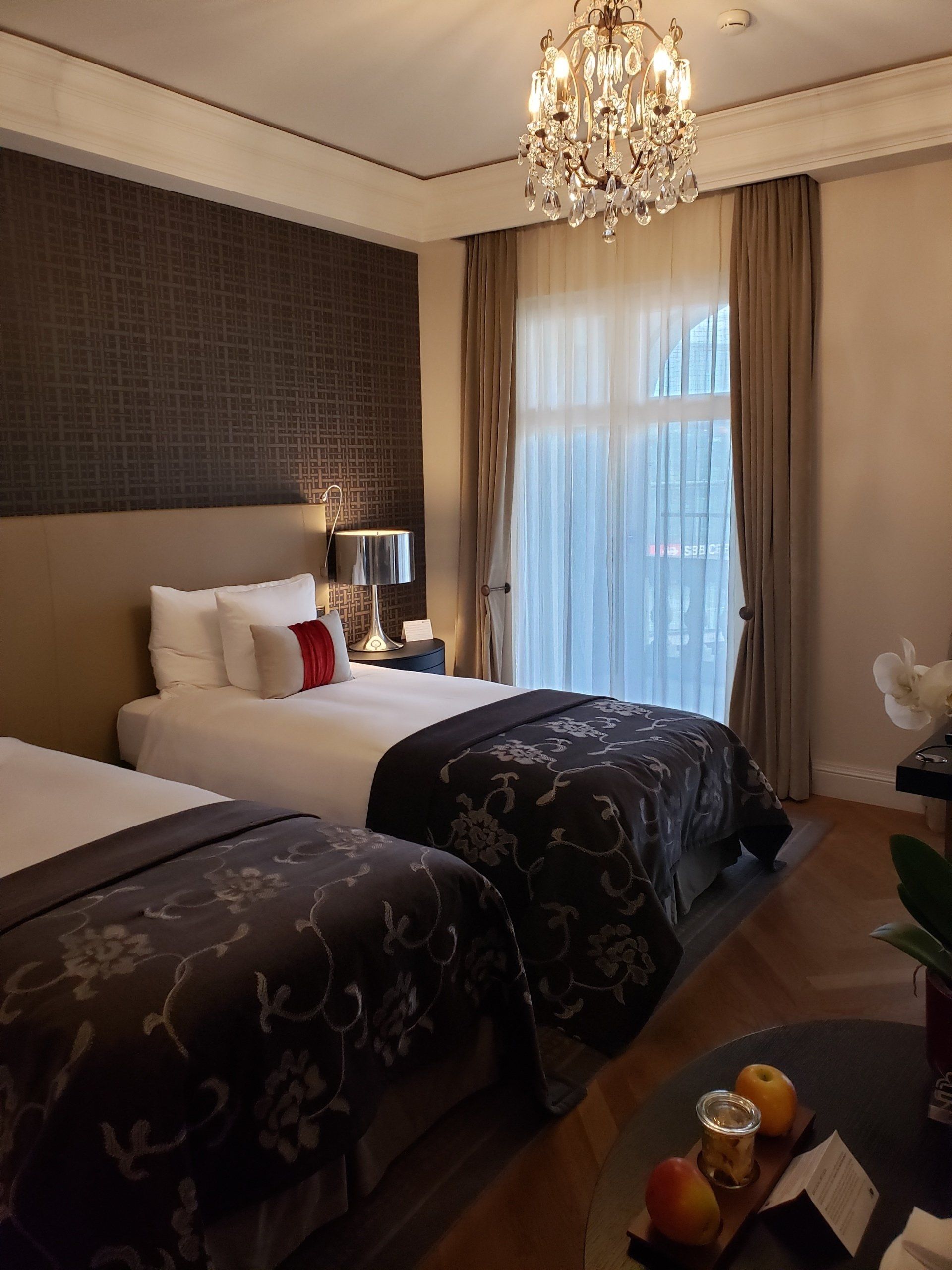 A hotel room with two beds and a chandelier