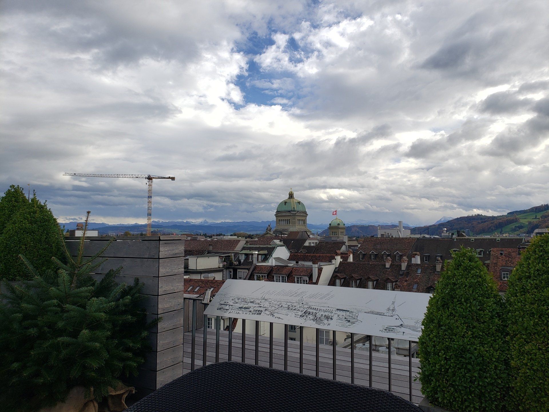 A view of a city from a balcony on a cloudy day.