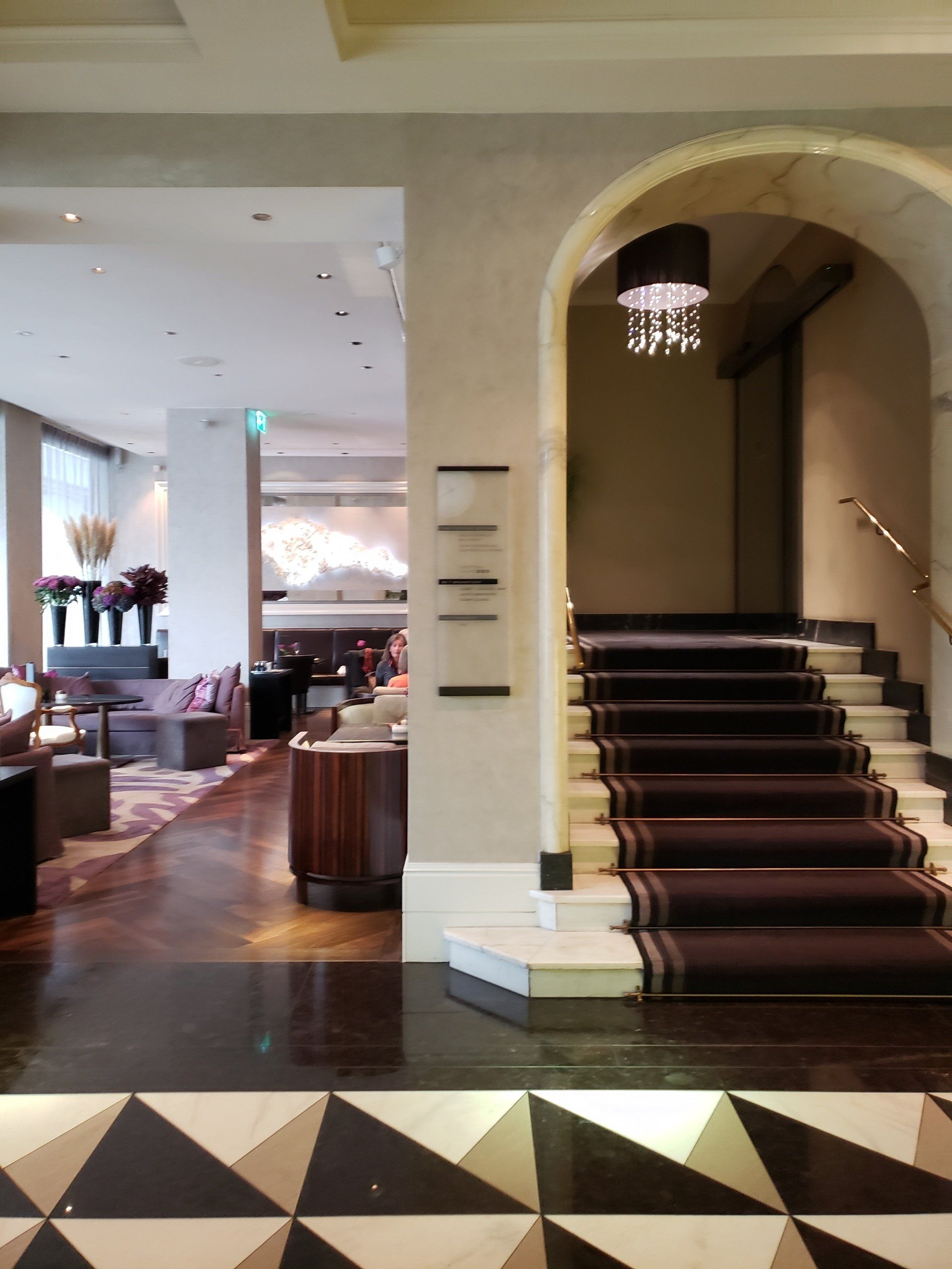 A hotel lobby with stairs leading up to the second floor