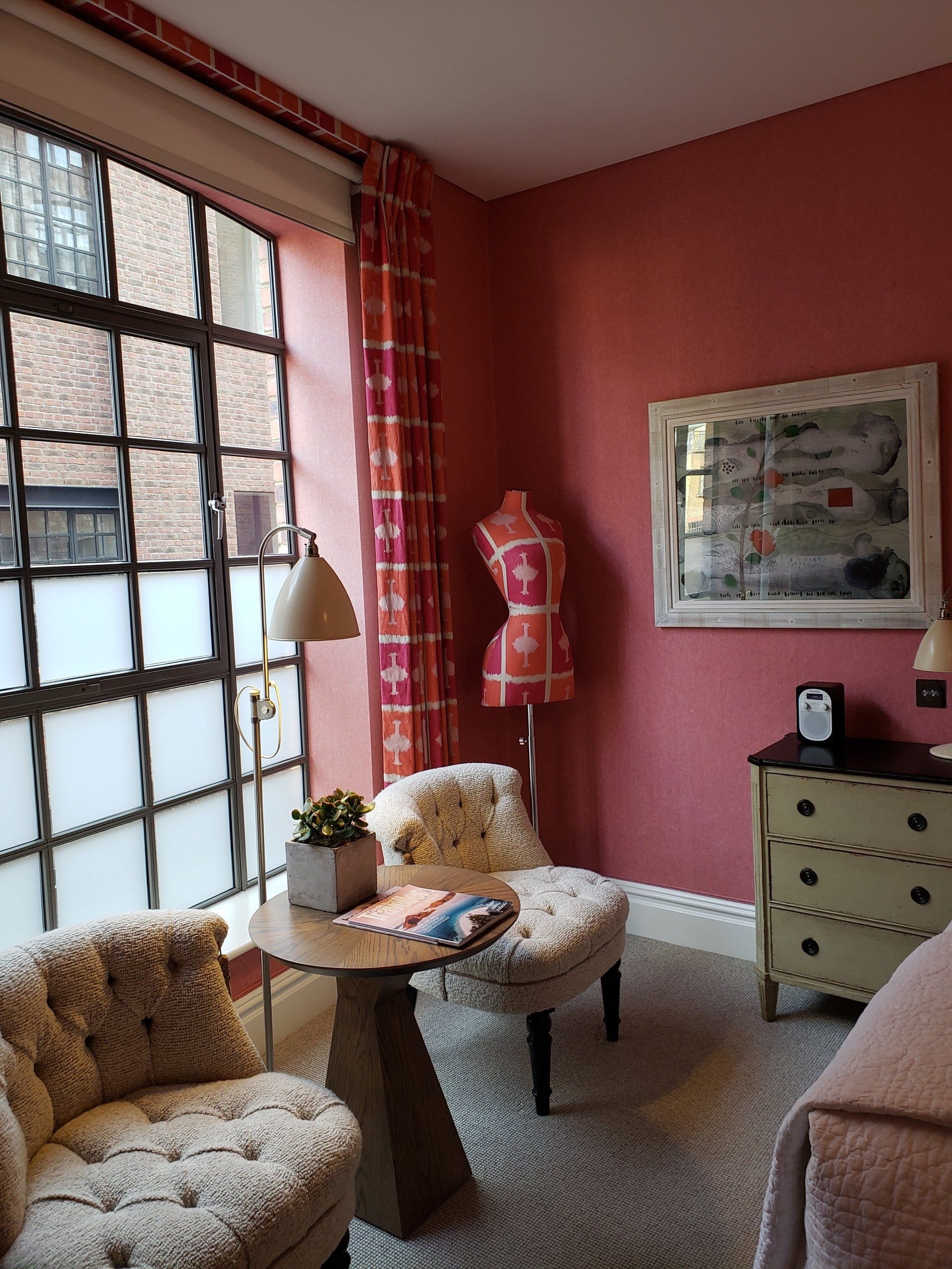 A living room with pink walls and white furniture